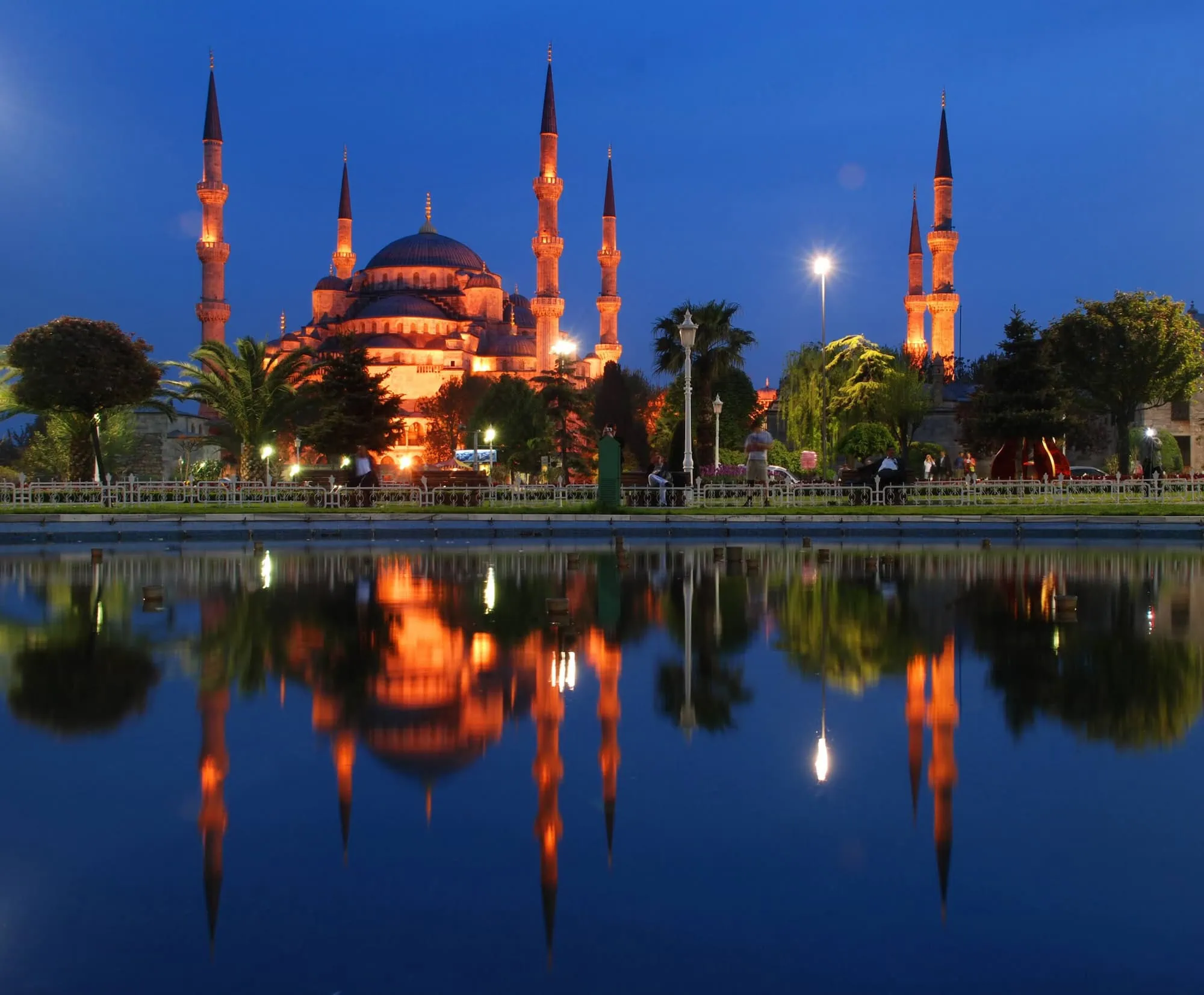The Blue Mosque with its distinctive six minarets and domes reflected in water at twilight