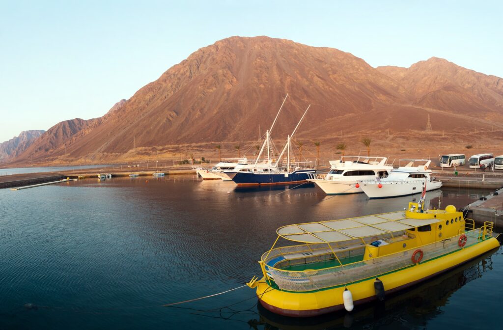 Boats and yachts moored in the harbor with surrounding shoreline visible, Taba