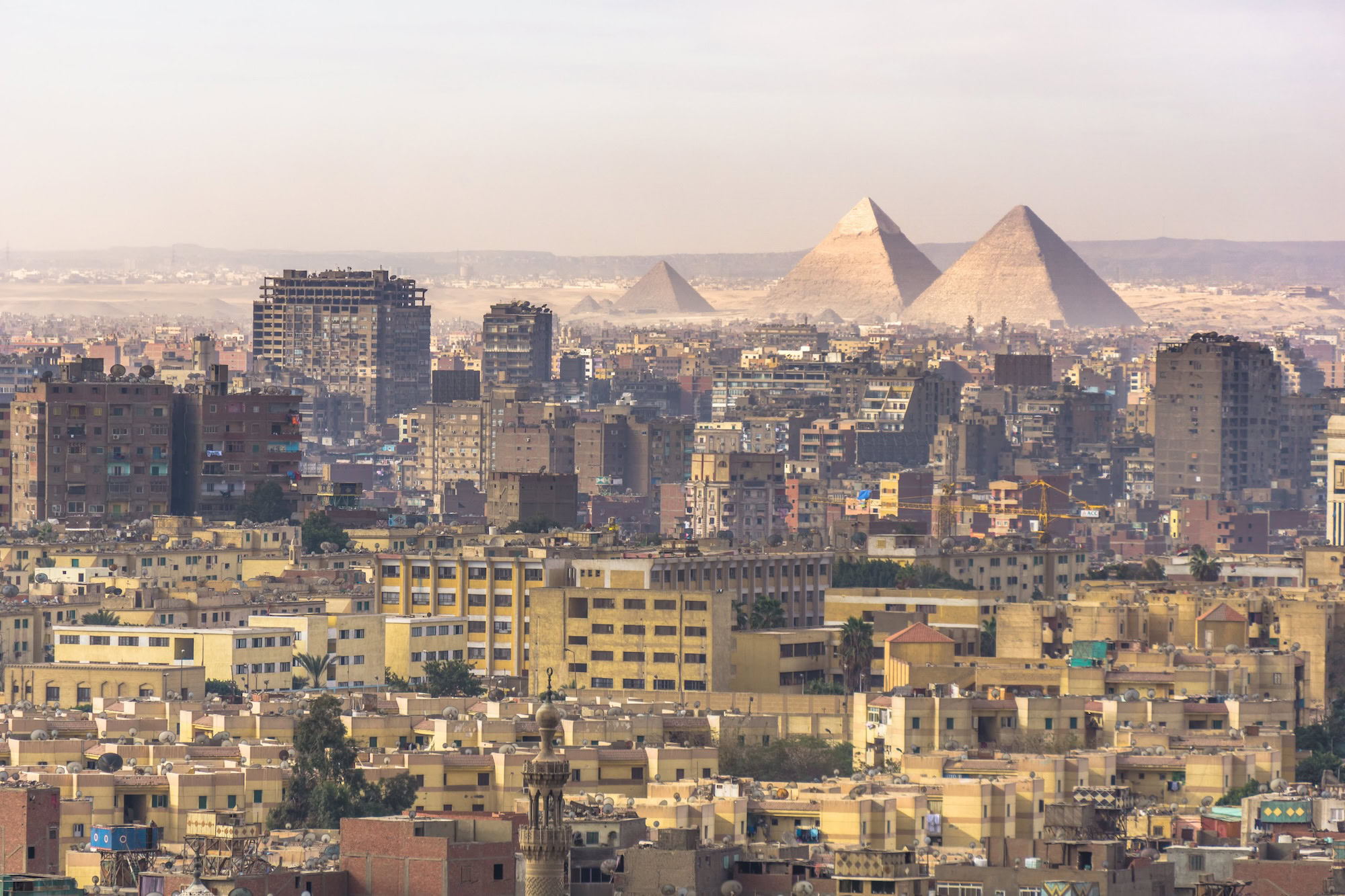 Aerial view of Giza pyramids with Cairo city skyline and urban sprawl