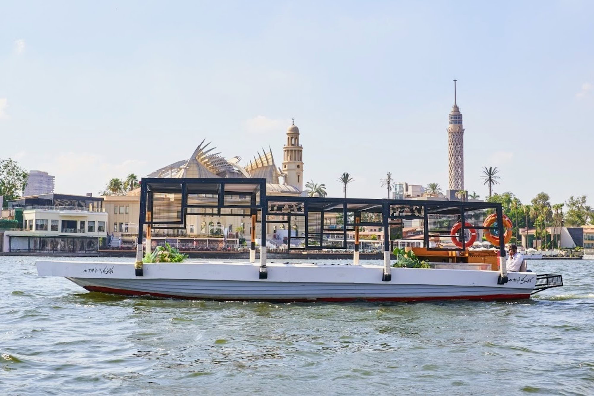 Boat on river with Cairo Tower and buildings in background