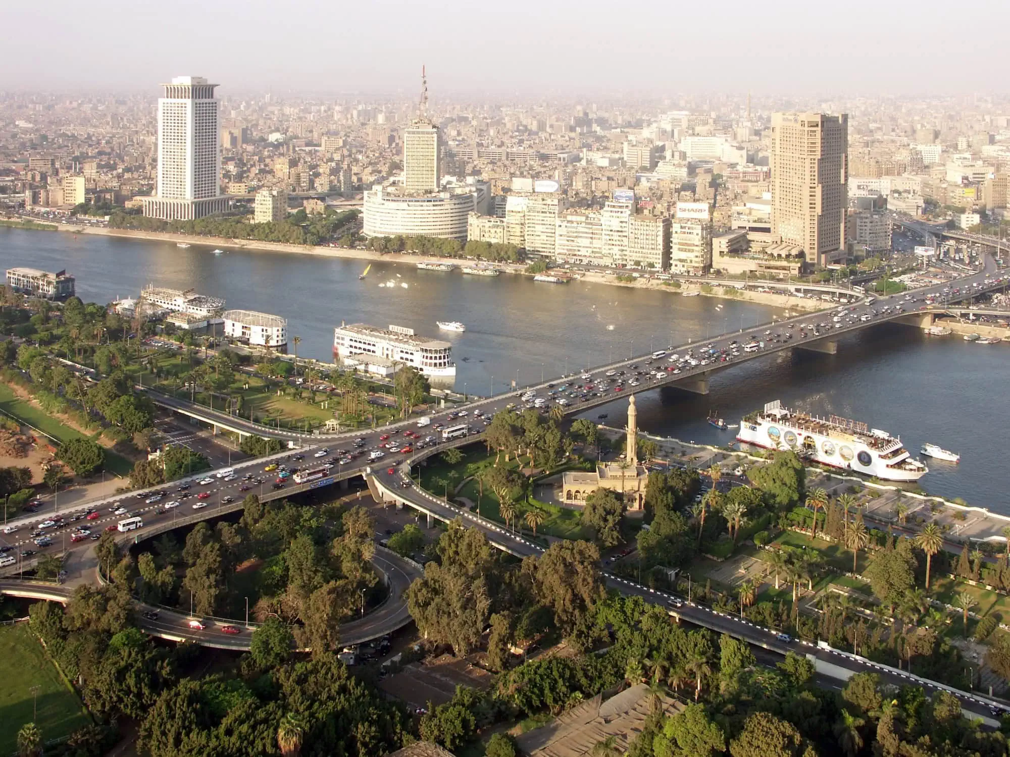 Aerial view of Cairo skyline with Nile River, bridges, and modern buildings