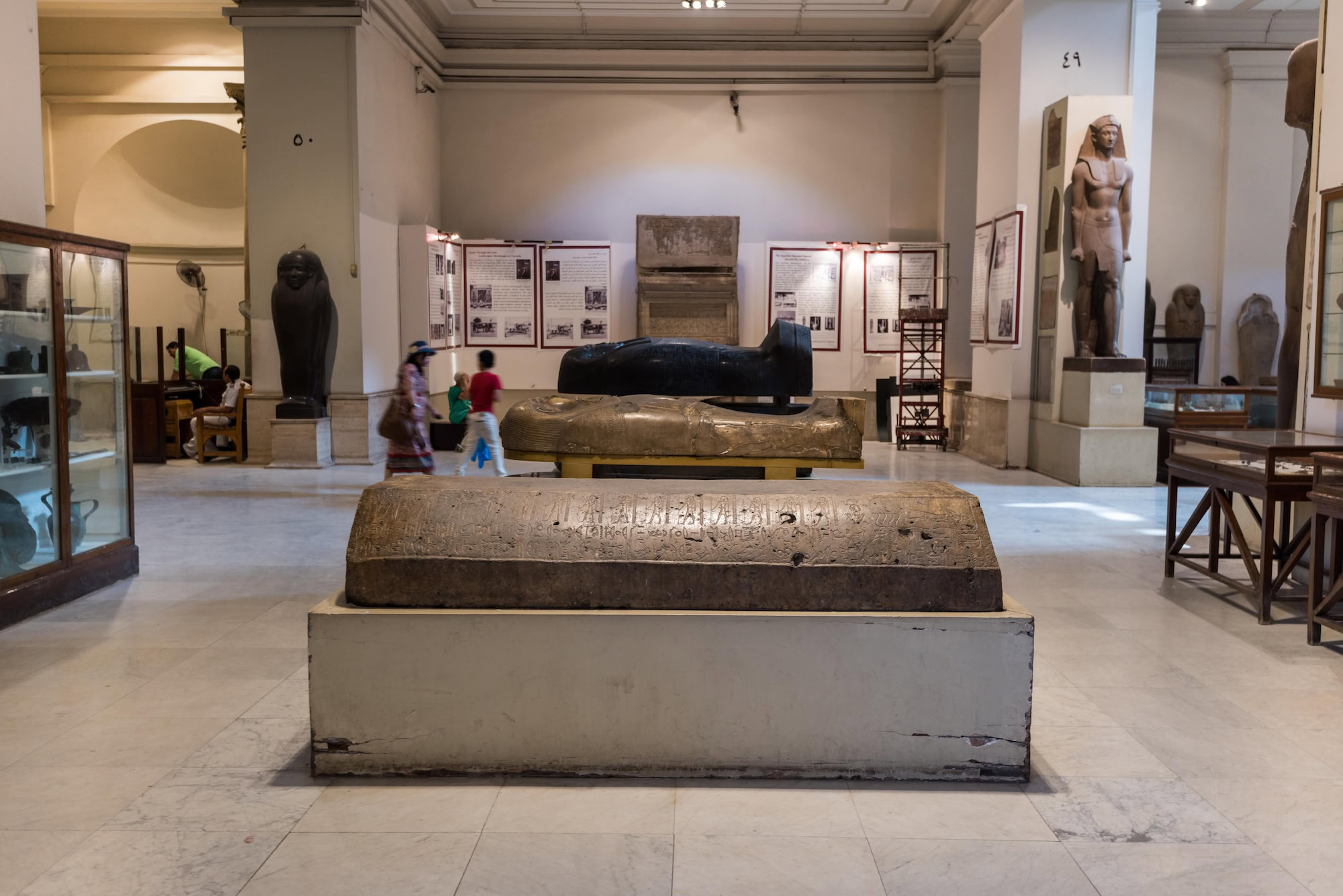 Interior view of Egyptian Museum displaying ancient sarcophagus, statues and hieroglyphic artifacts