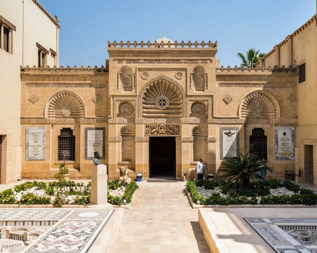 An exterior view of the historic facade and courtyard architecture of the Coptic Museum, Cairo