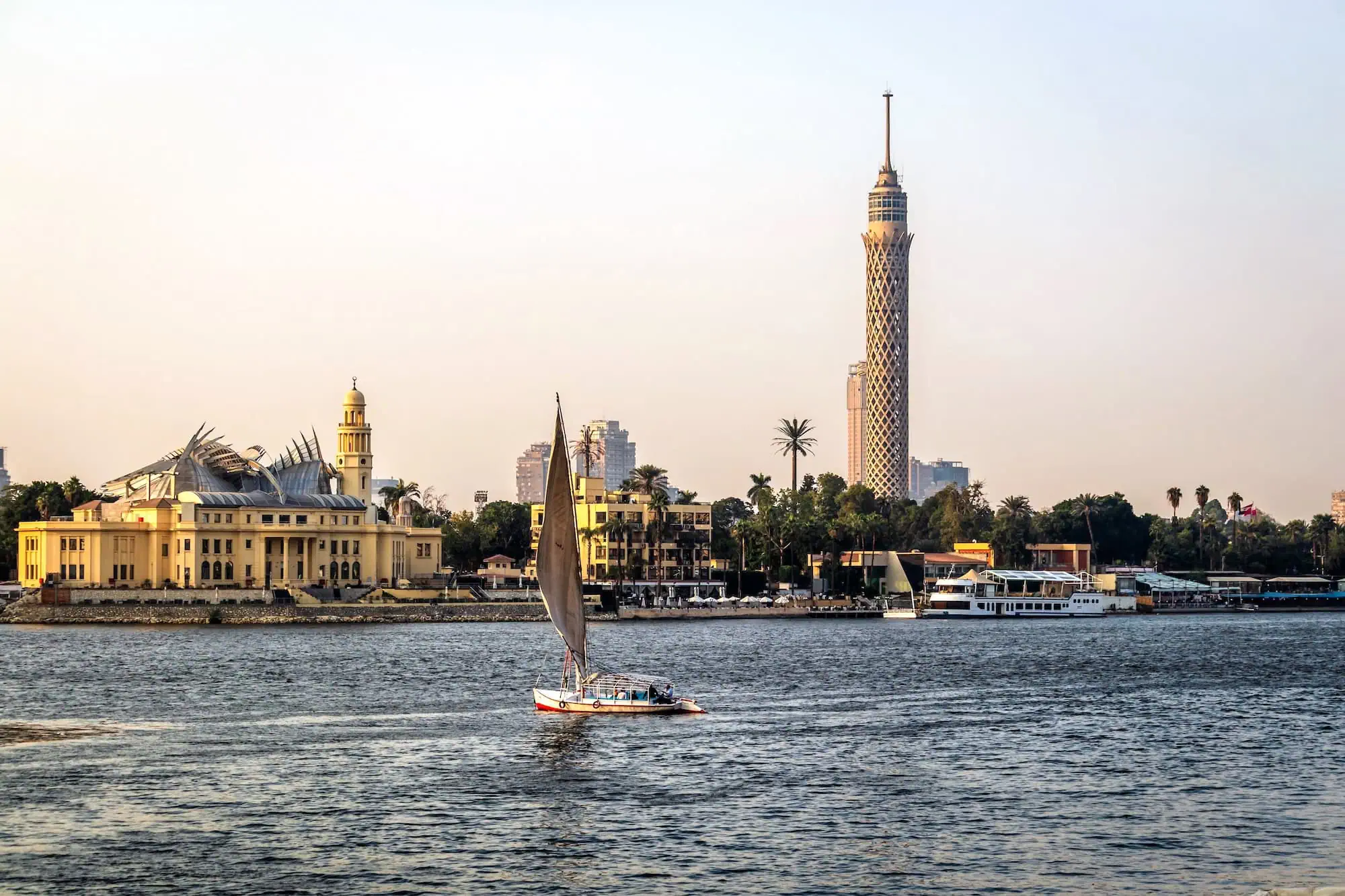 Traditional felucca sailboat on the Nile River in Cairo with Cairo Tower in background