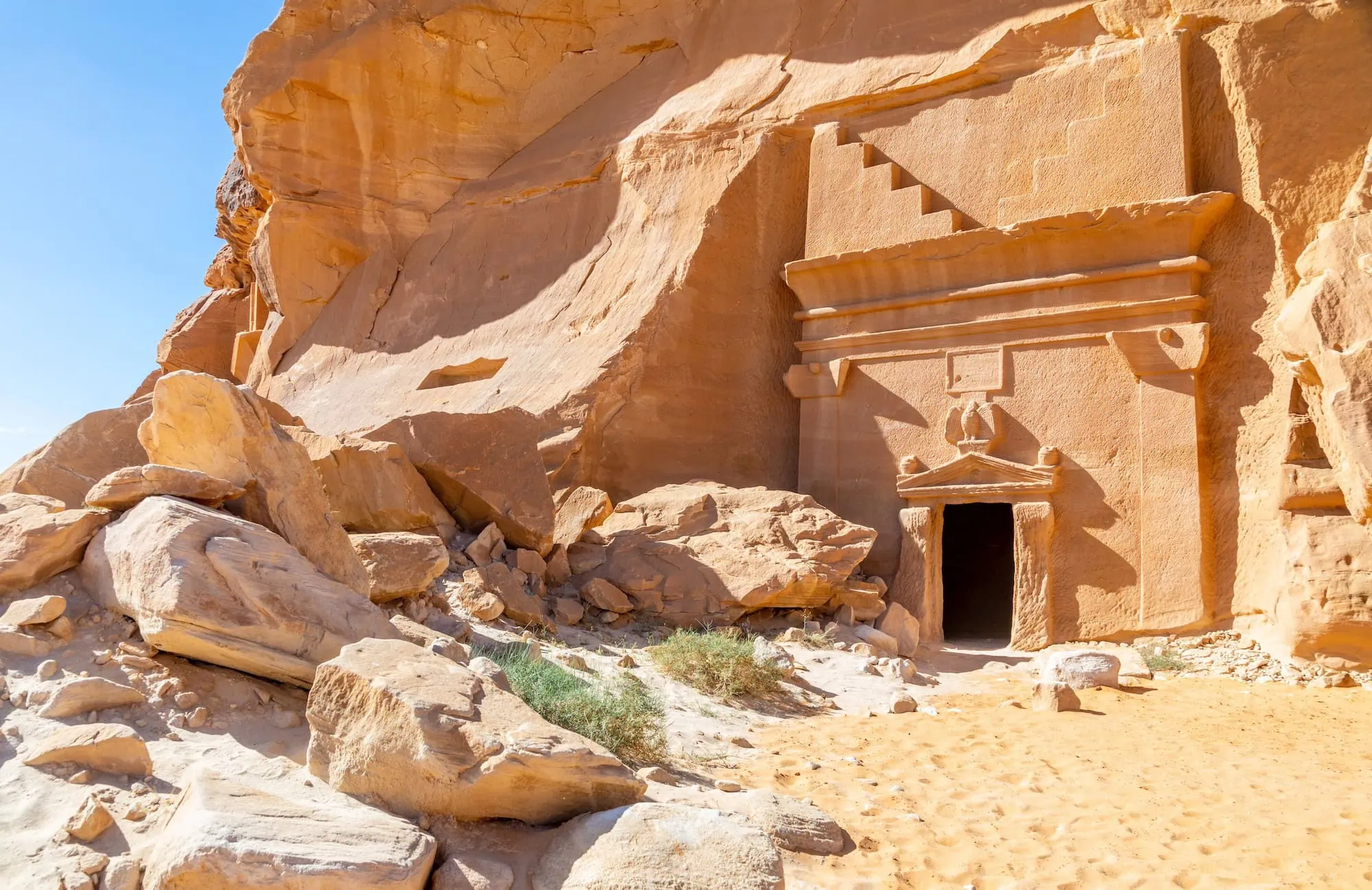 Ancient Nabataean tomb carved into sandstone cliff at Hegra archaeological site in AlUla