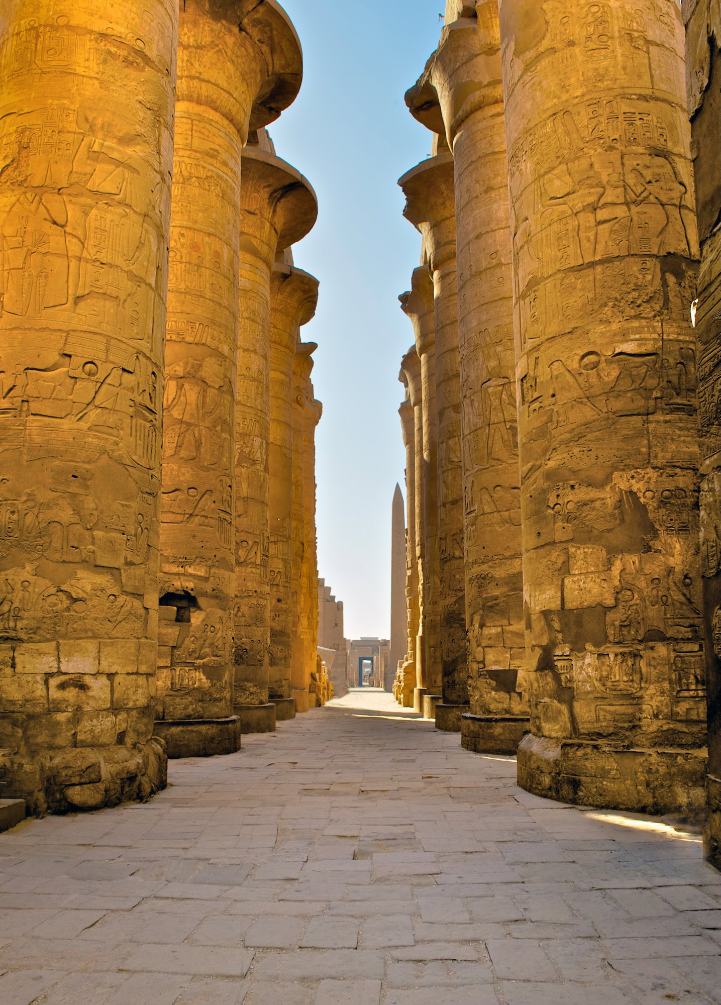 Colunas imponentes do Templo de Karnak com hieróglifos e esculturas em pedra
