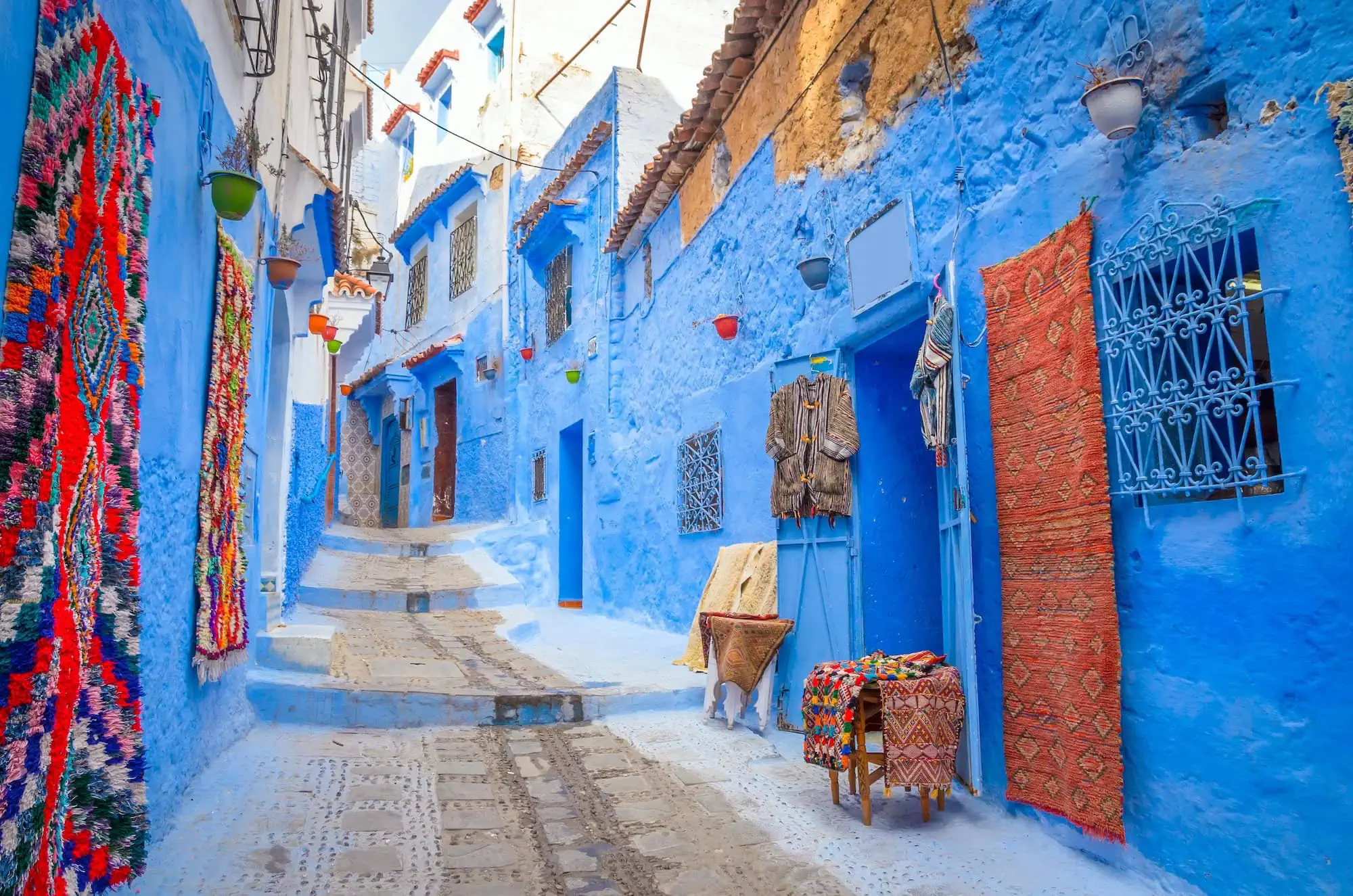 Blue painted street in Chefchaouen with traditional Moroccan buildings and colorful handicrafts