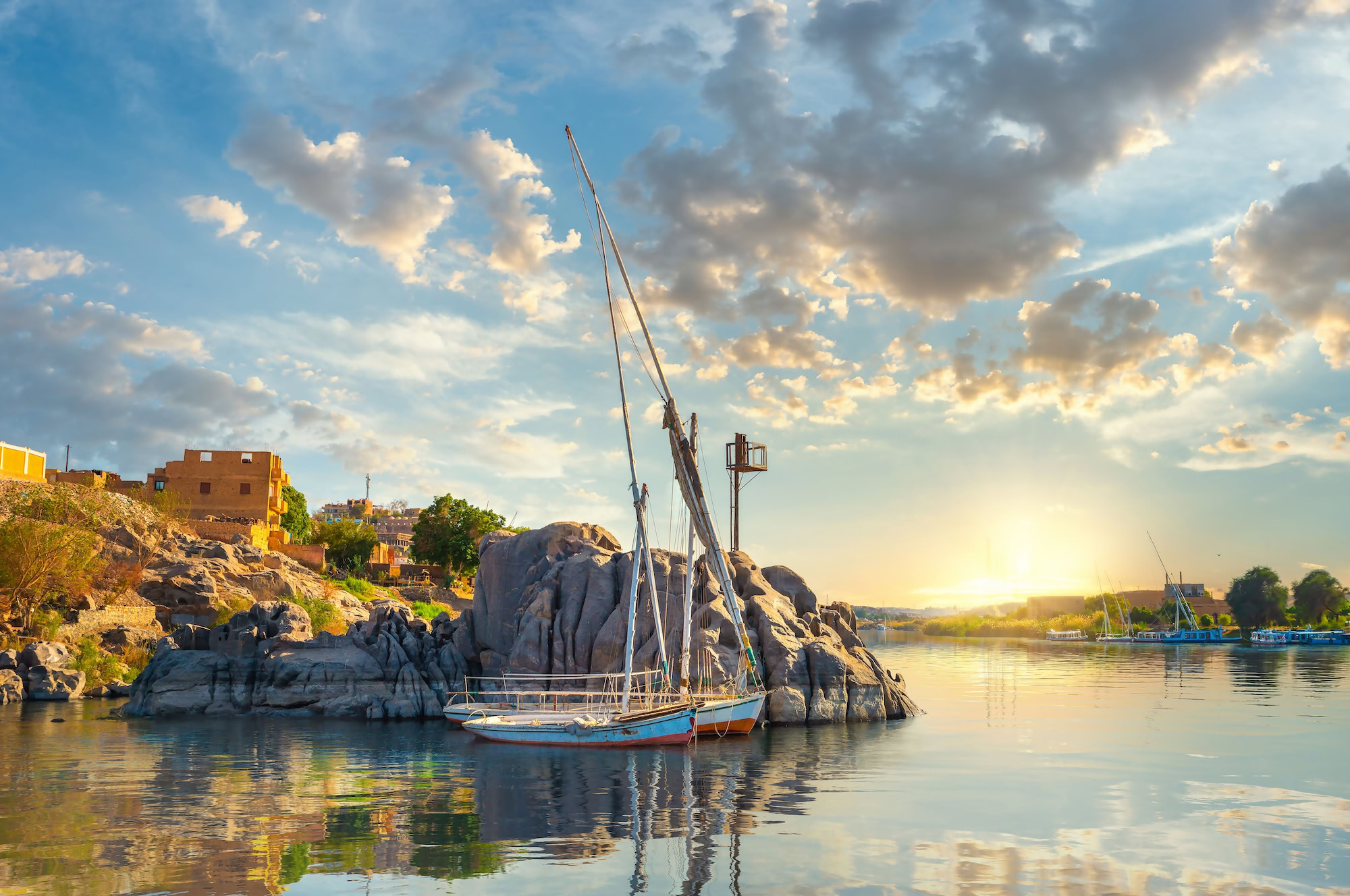 Traditional felucca sailboat on the Nile River near Aswan's granite rocks