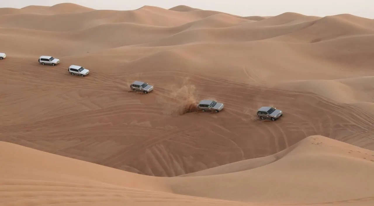 Column Of Jeeps Travelling In Sand Desert