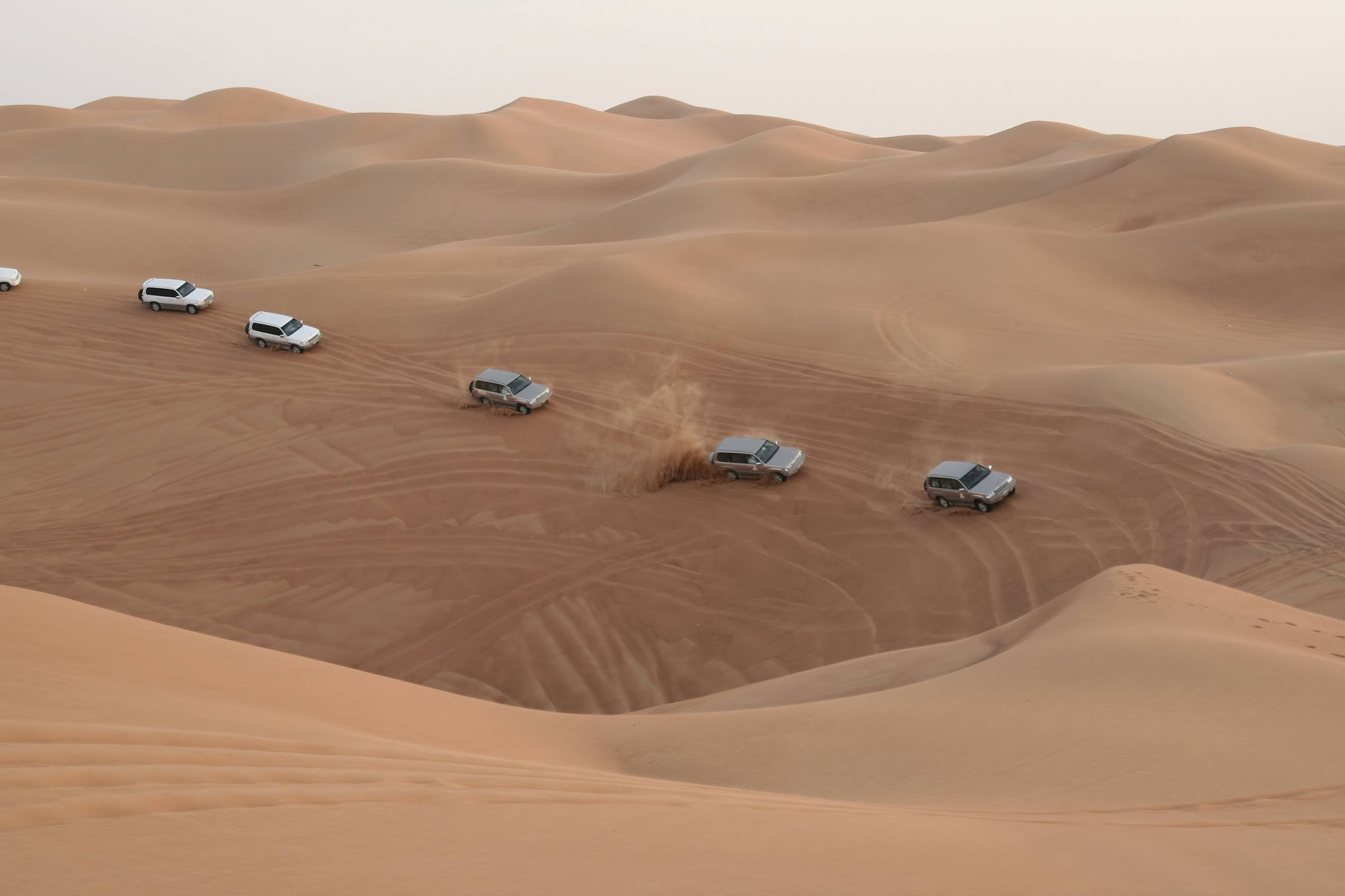 Column Of Jeeps Travelling In Sand Desert