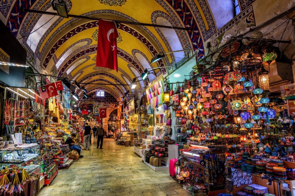 Interior of the Grand Bazaar in Istanbul – also known as the Covered Bazaar – with vaulted ceilings, colorful shops, and vibrant stalls selling Turkish goods.
