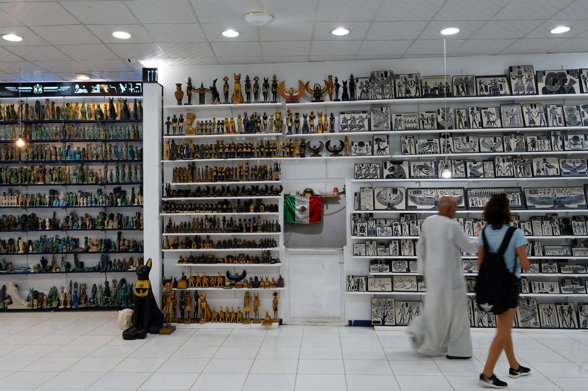 Interior of Egyptian souvenir shop with pharaoh statues and hieroglyphic artwork on shelves