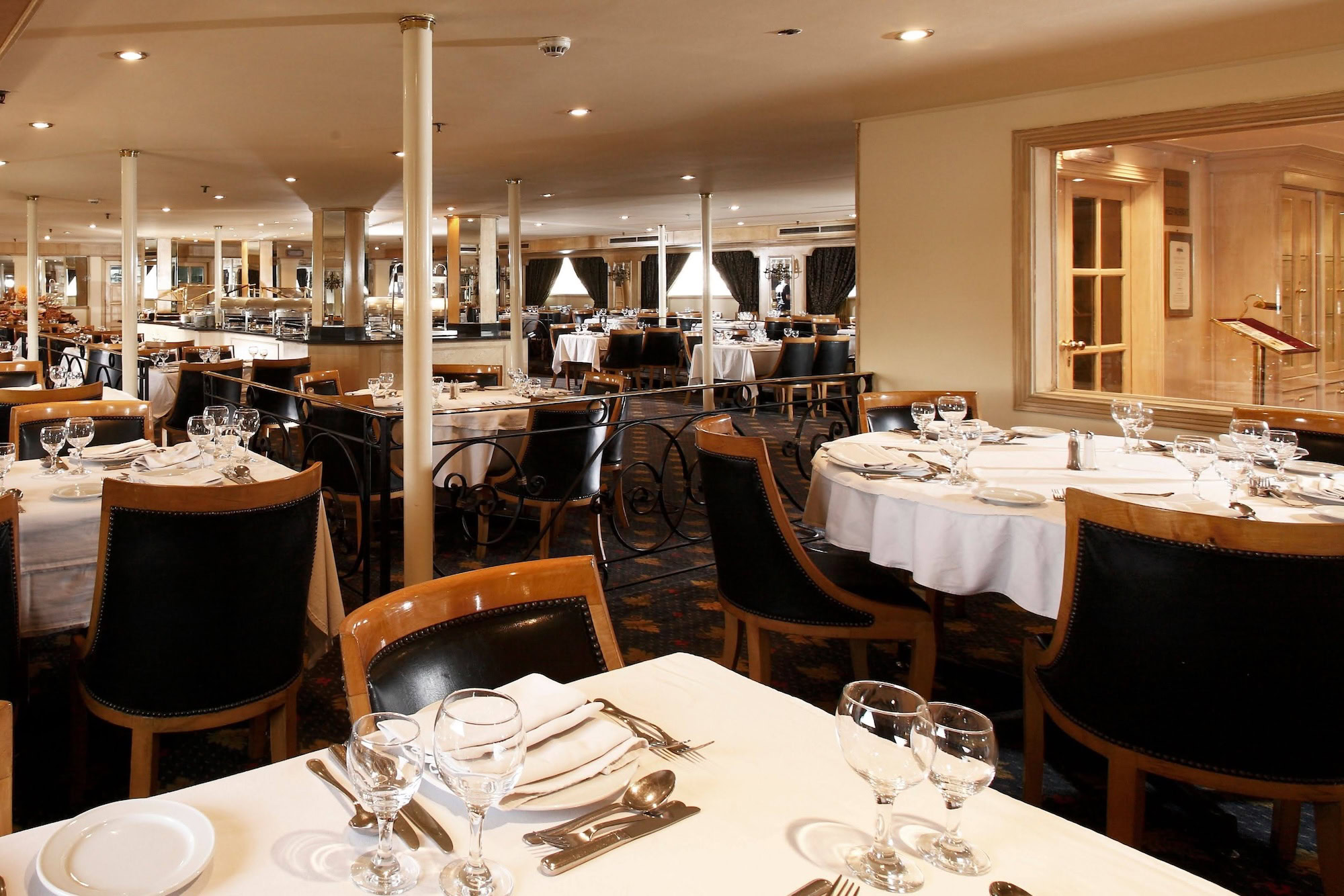 Ristorante a bordo della Crown Jewel con tavoli apparecchiati e vista sul Nilo