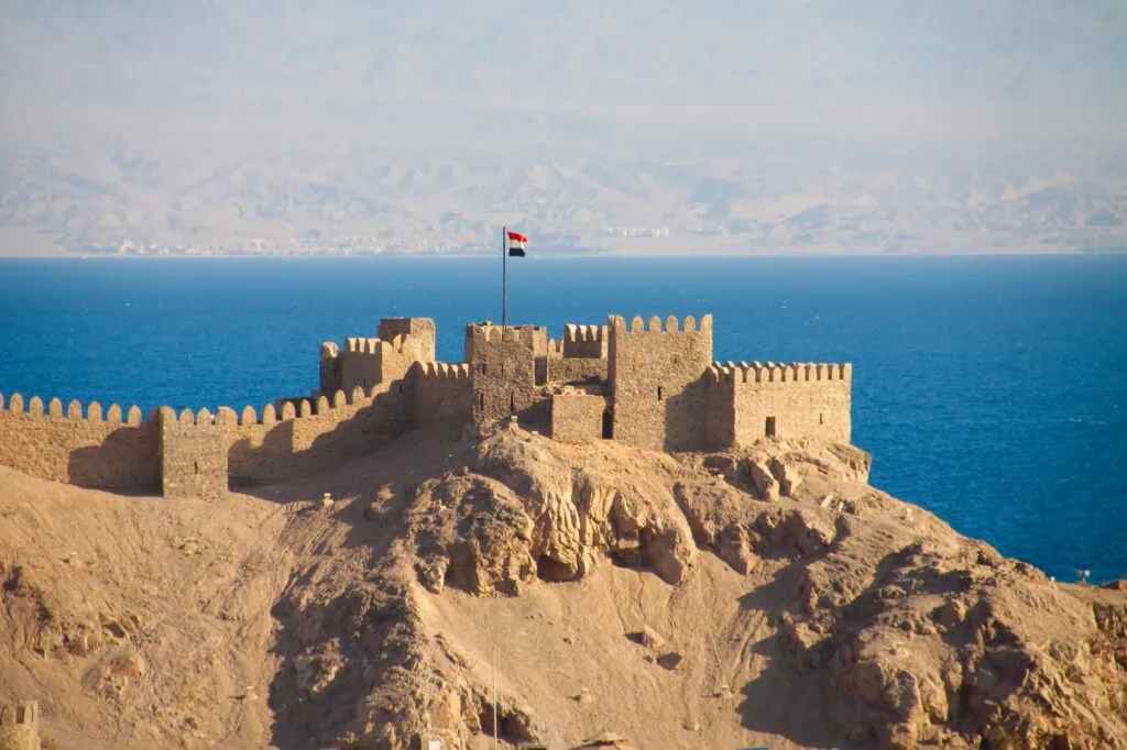 Crusader fortress overlooking the Red Sea with distant mountains visible across the water, Taba