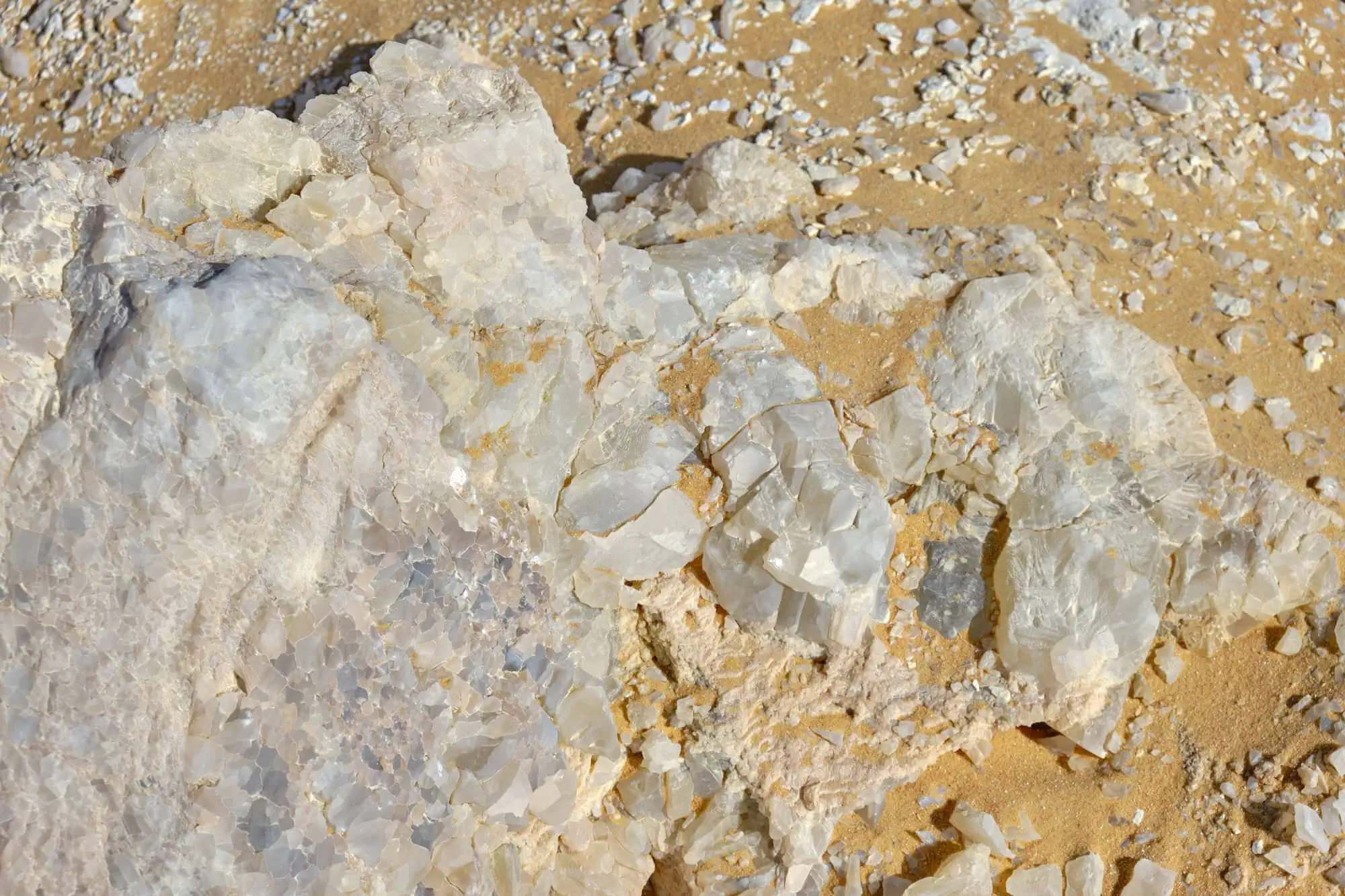 Close-up view of white quartz crystals embedded in tan limestone rock at Crystal Mountain