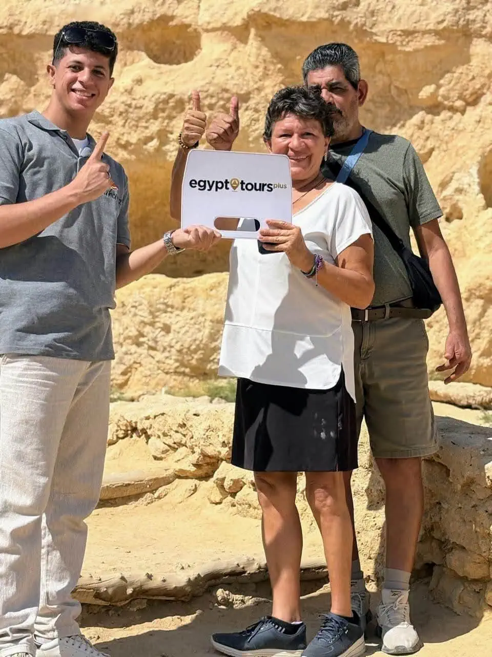 Tourists on a guided tour at ancient Egyptian archaeological site with limestone structures
