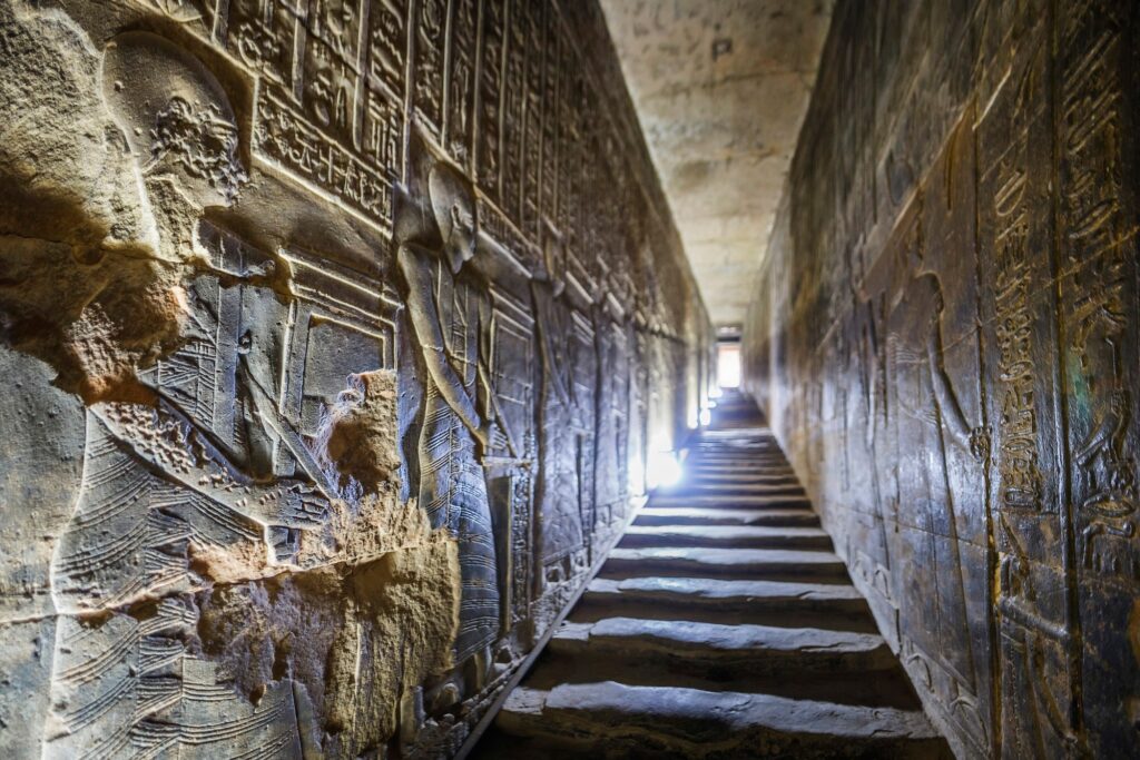 Stone corridors lined with carved hieroglyphs and relief scenes inside the Temple of Hathor at Dendera, Dendera