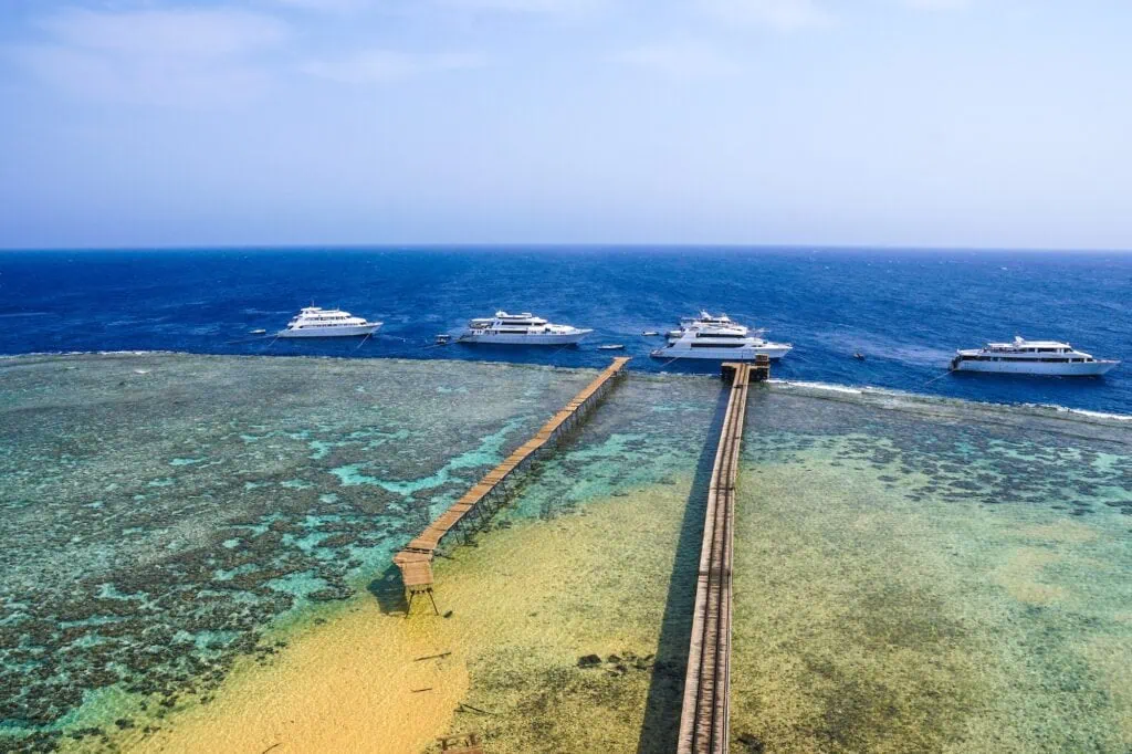 Daedalus Reef Lighthouse with moored yachts and surrounding coral reefs, Marsa Alam