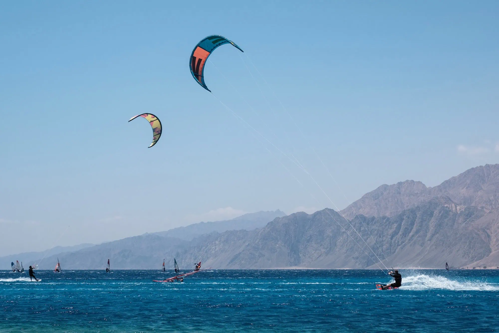 Kitesurfing and windsurfing with colorful kites over Red Sea waters
