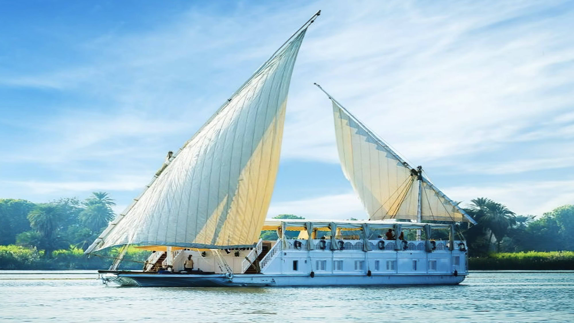 Traditional felucca sailboat with passengers on the Nile River in Egypt