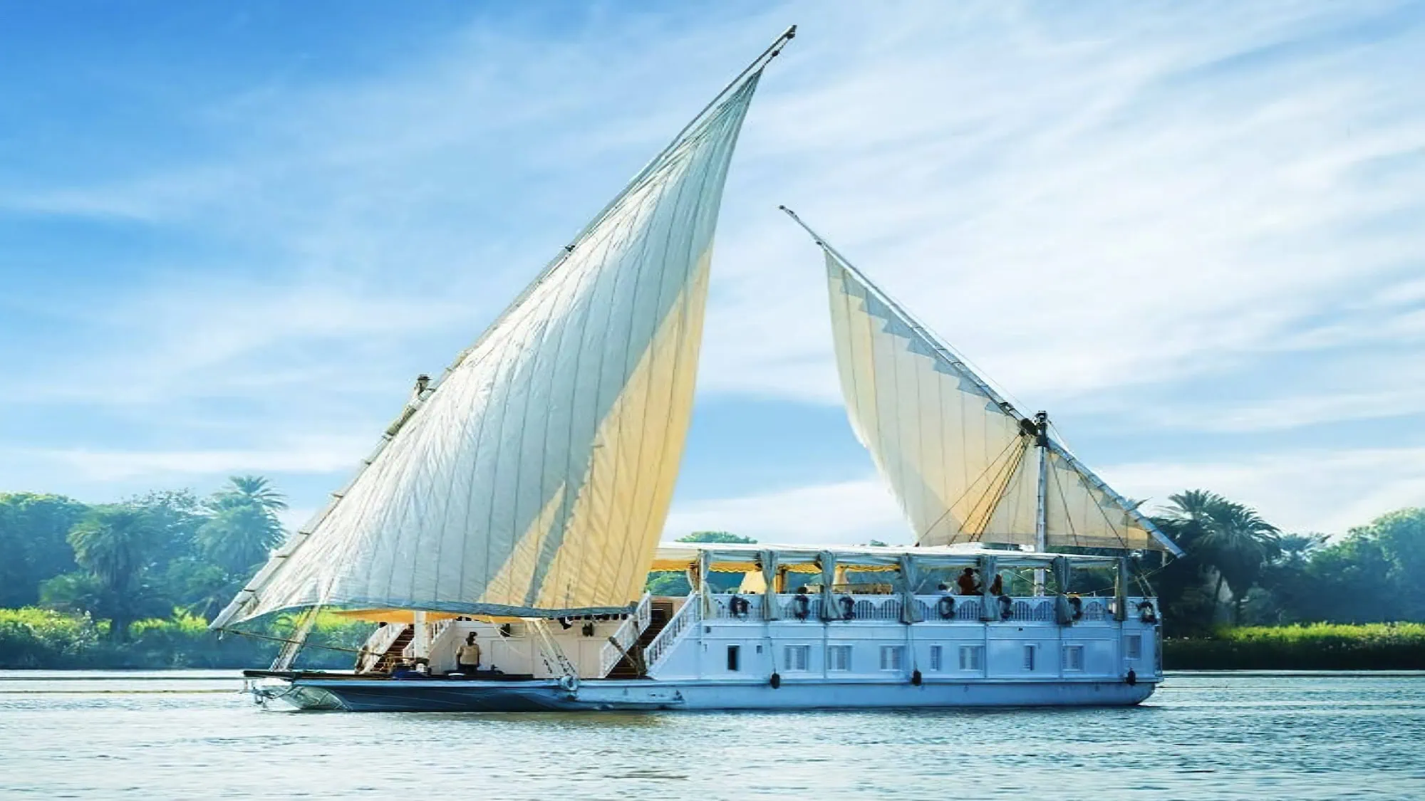 Traditional felucca sailboat with passengers on the Nile River in Egypt