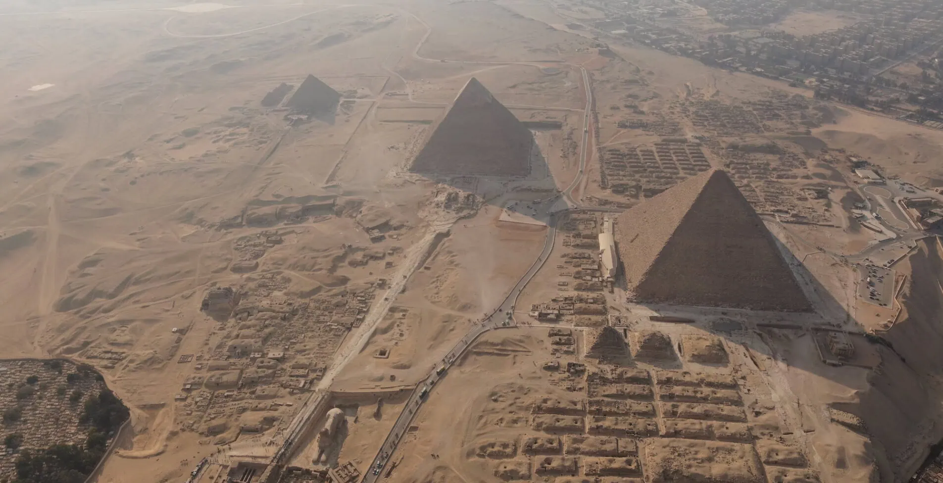 Dark hazy Giza Pyramids and the Sphinx aerial view 1905x976 crop 50 73
