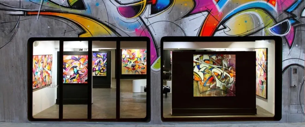 David Bloch Gallery interior with glass facade revealing colorful abstract graffiti-style paintings on display Marrakech