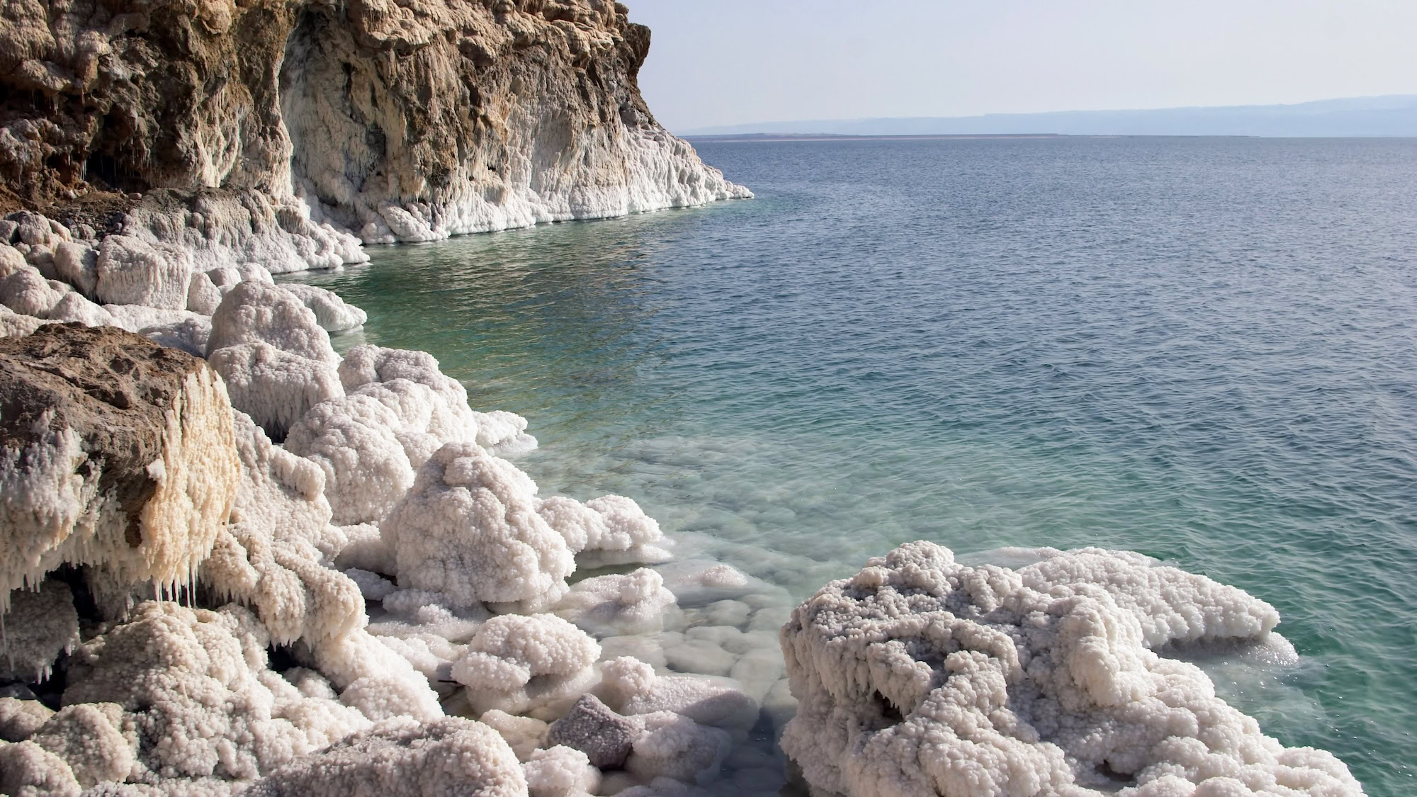 Dead Sea salt formations and mineral deposits along rocky shoreline
