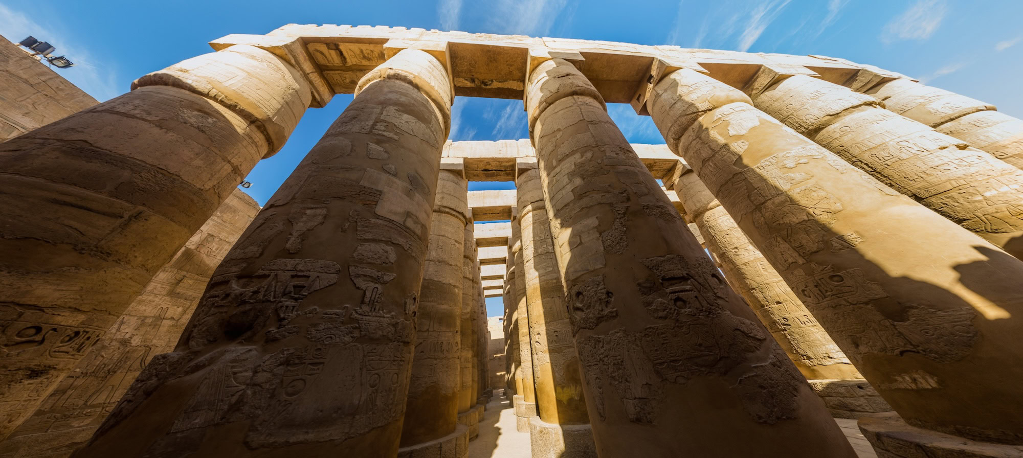 Towering ancient columns with hieroglyphs inside Karnak Temple complex