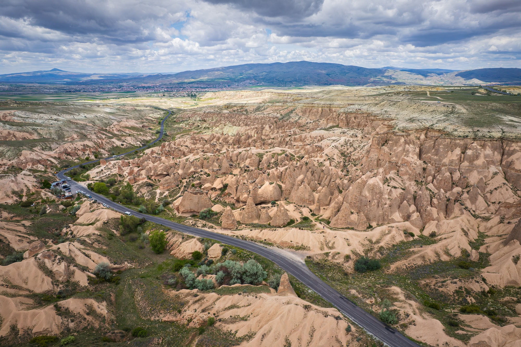 Dramatic red and pink rock formations in Cappadocia valley with winding road