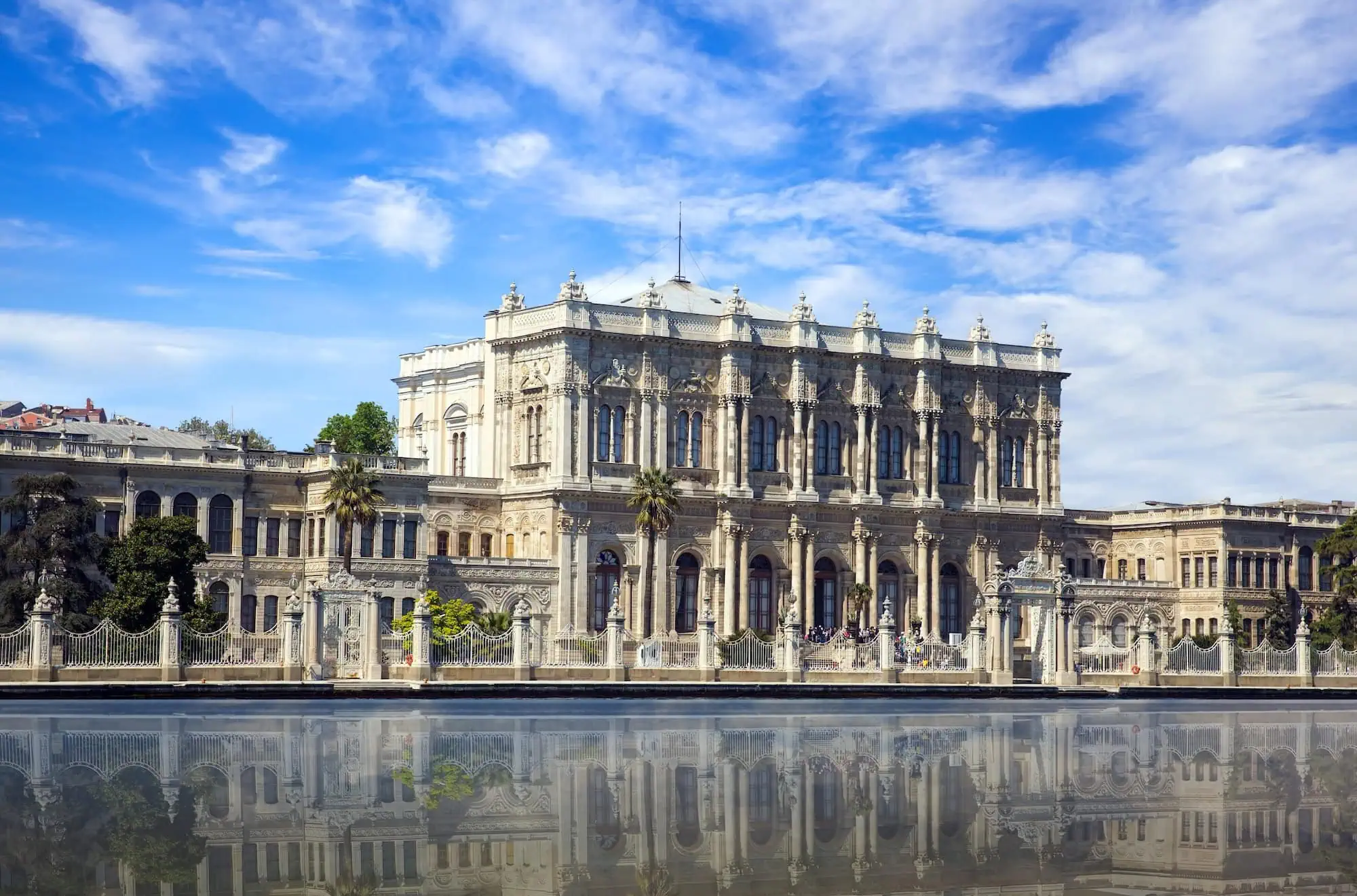 Dolmabahçe Palace exterior reflected in calm waters with blue sky