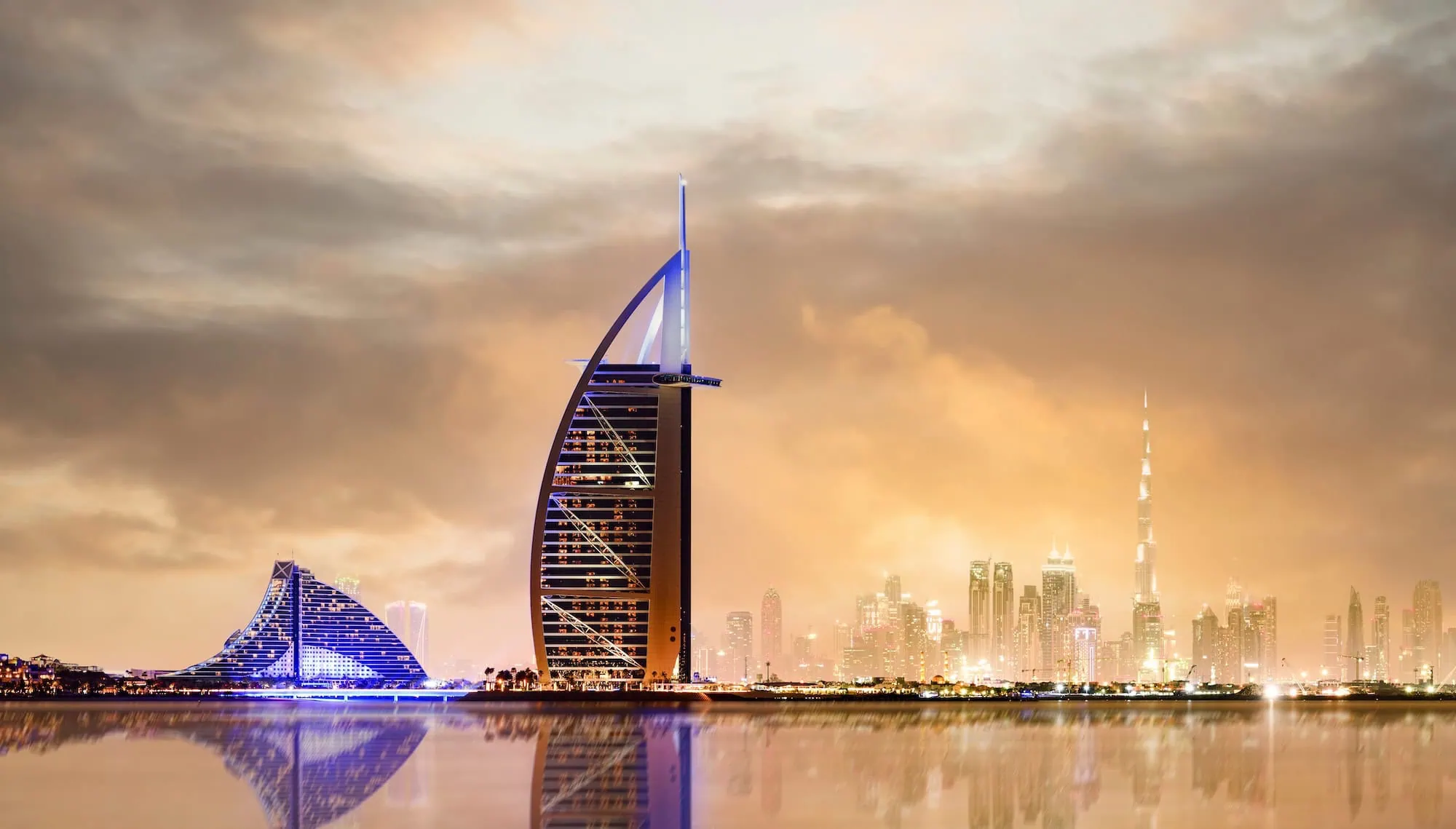 Dubai's iconic Burj Al Arab sail-shaped hotel towering over the city skyline with reflections