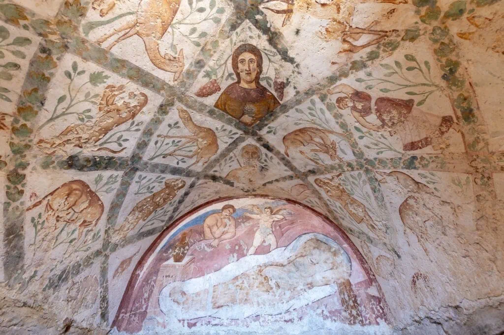 Wall painting depicting human figures and decorative motifs inside Qasr Amra, Azraq