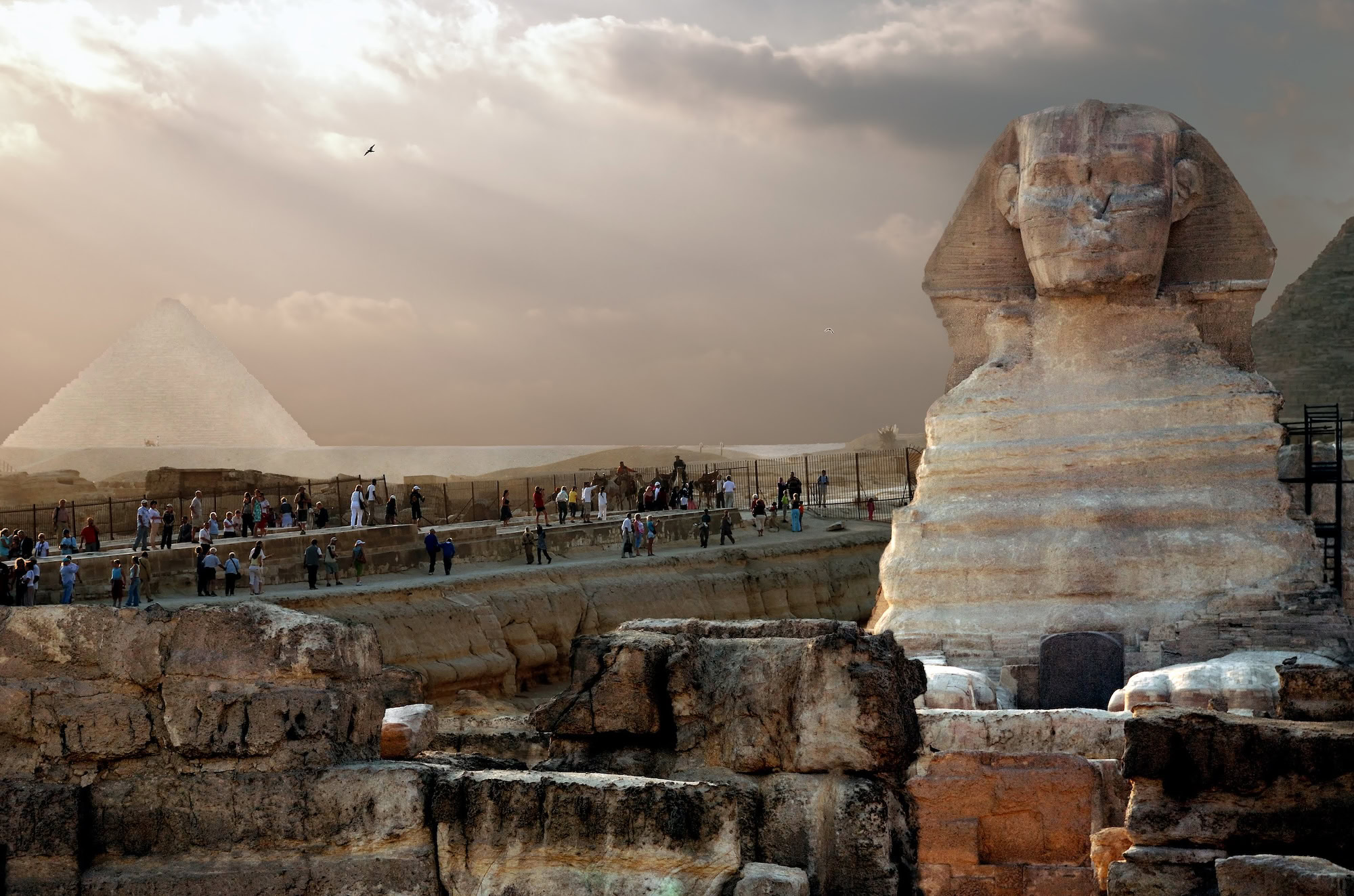 Esfinge e Pirâmide de Gizé com turistas visitando o sítio arqueológico