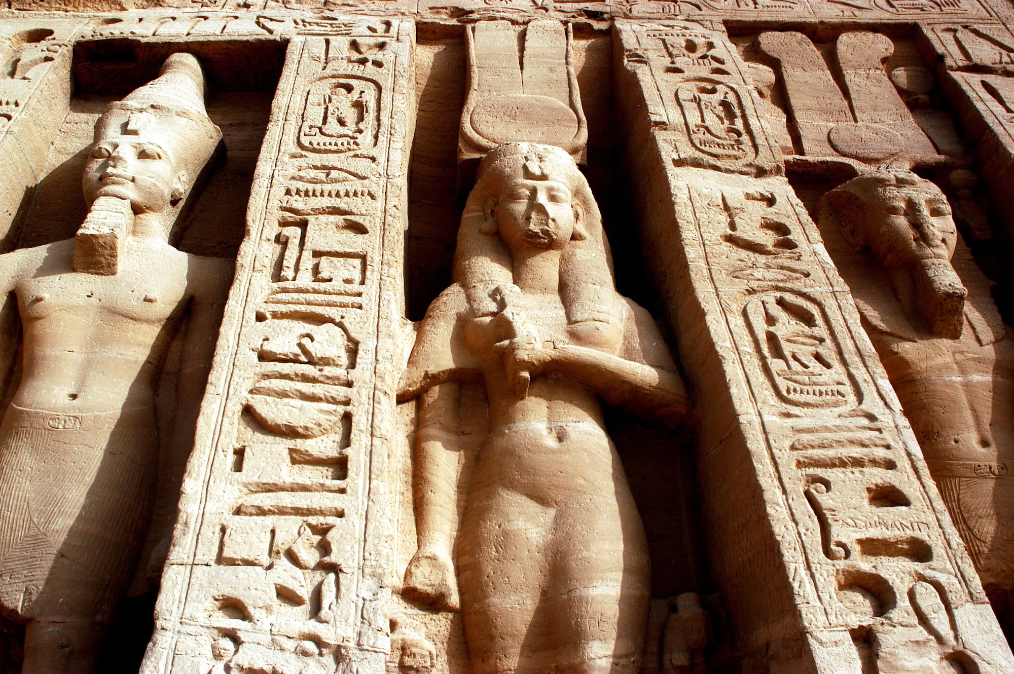 Abu Simbel temple facade with colossal pharaoh statues and hieroglyphic inscriptions