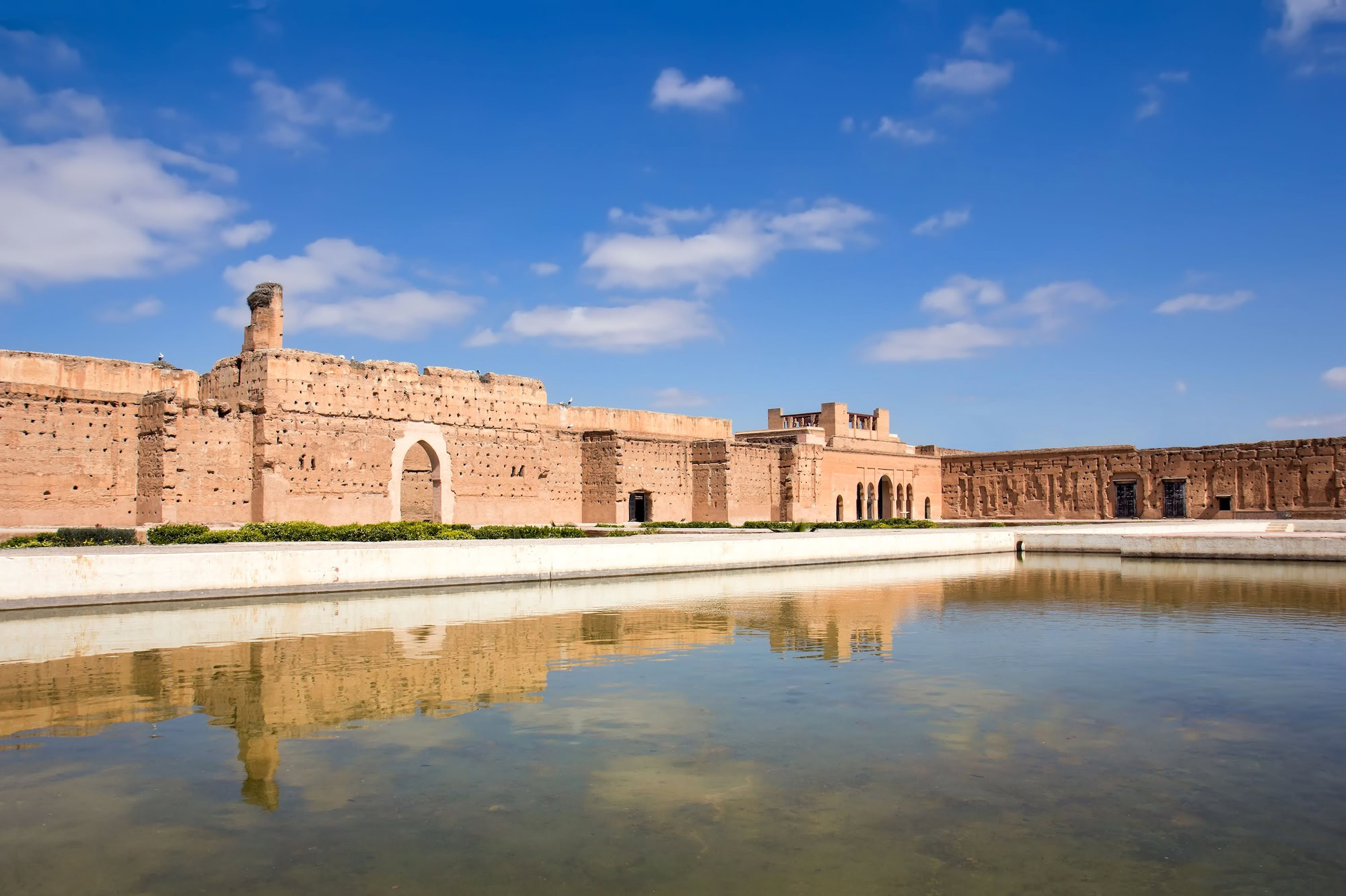 Serene El Badi Palace ruins with reflecting pool and ancient archways in Marrakech