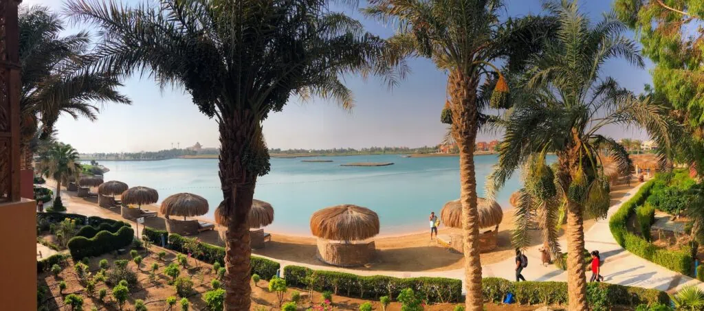Palm-lined resort with walkways beside calm blue water in El Gouna