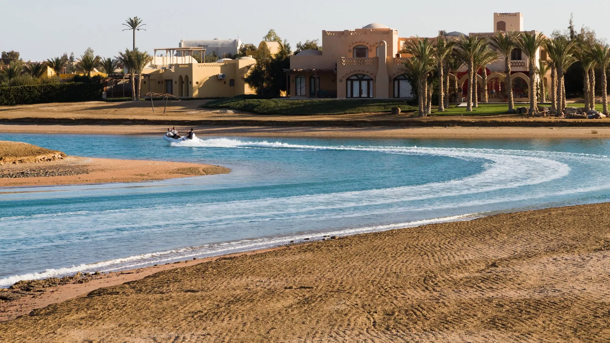 Beach scene in El Gouna with jet ski on blue water and sandy shoreline