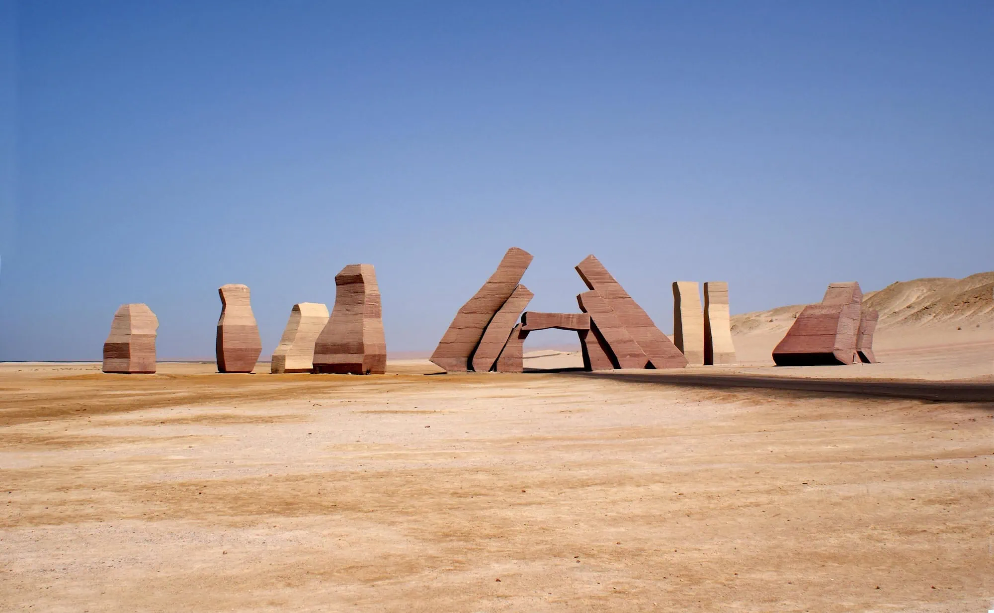 Stone letters spelling Ras Mohammed in desert landscape with clear sky