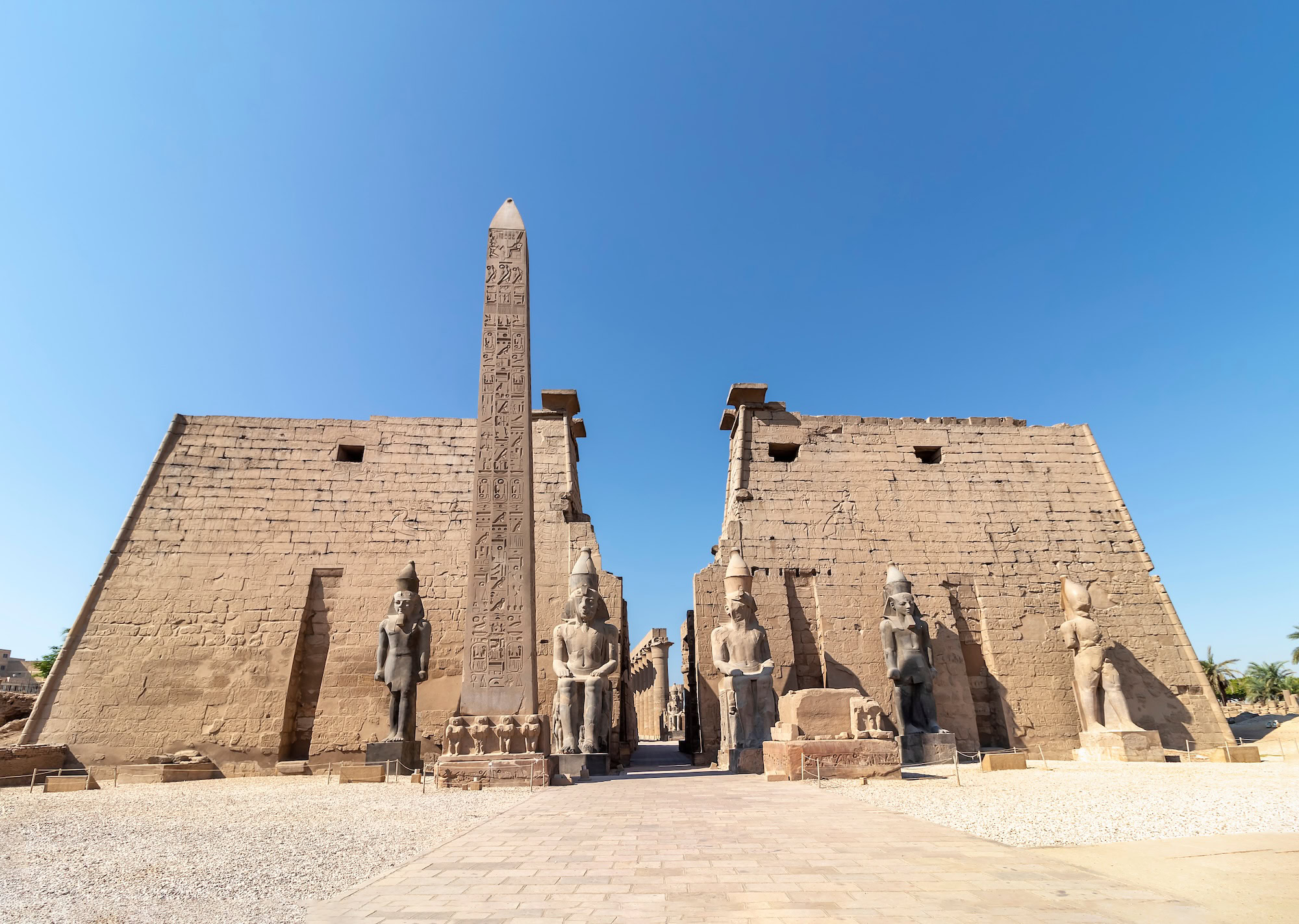 Ancient Egyptian obelisk and temple entrance at Luxor Temple with hieroglyphic carvings