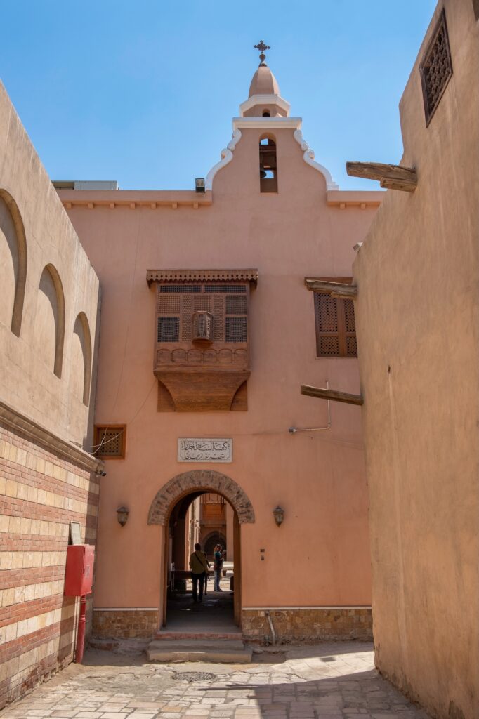 The main entrance with stone doorway and wooden doors of the Coptic Orthodox Church of Saint Barbara, Cairo