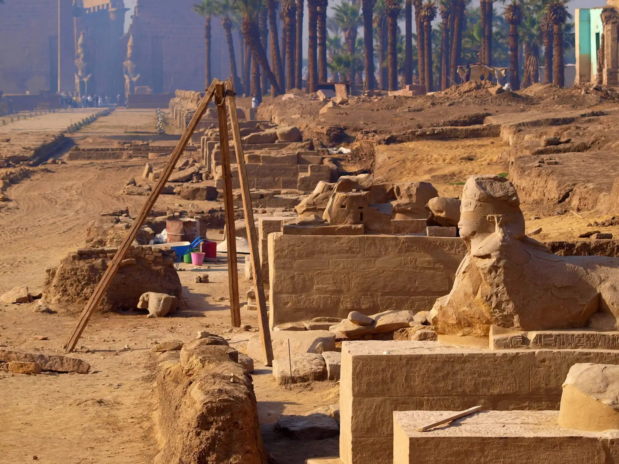 Archaeological excavation site in Egypt with wooden surveying equipment and ancient stone structures