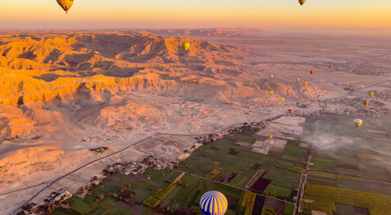 Luxor hot air balloon ride over the Nile Valley – stunning aerial view showing the contrast between green fields and the surrounding desert