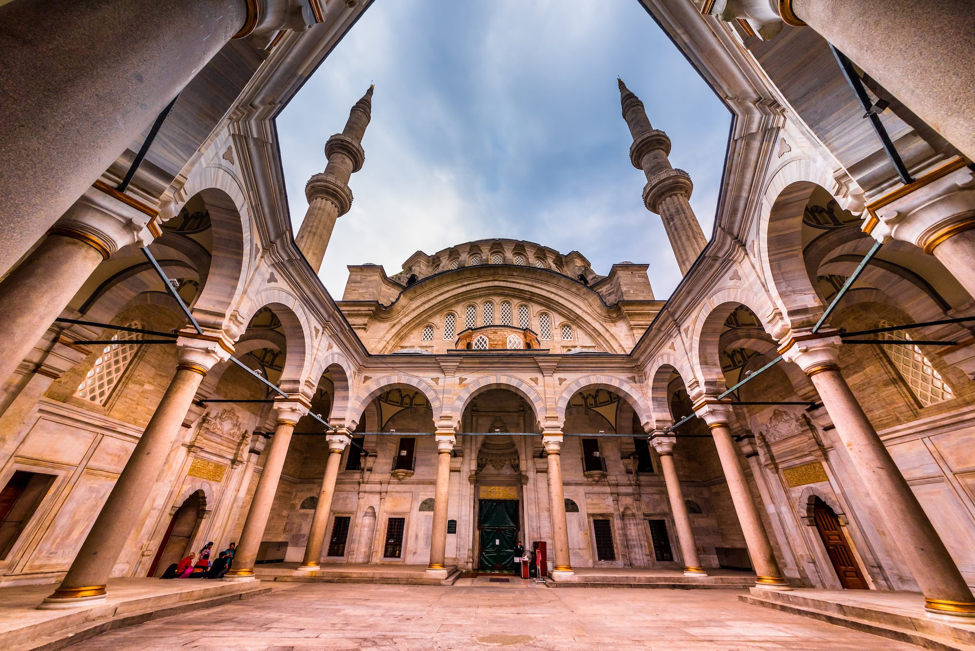 Majestic Ottoman mosque with minarets, dome, and stone courtyard in Turkey