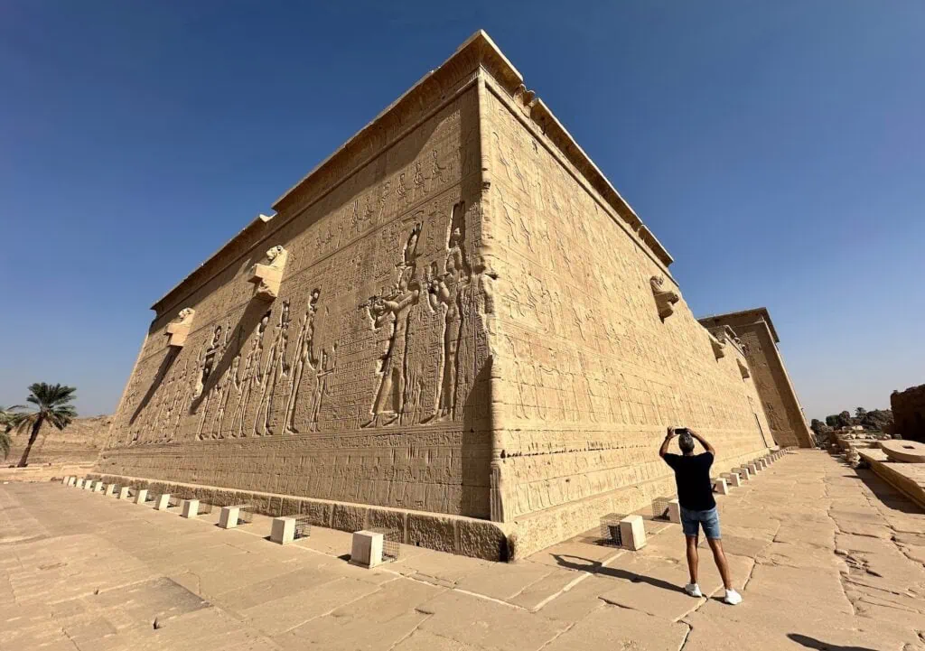 Exterior view of the massive stone walls carved with relief scenes at Dendera Temple, Dendera