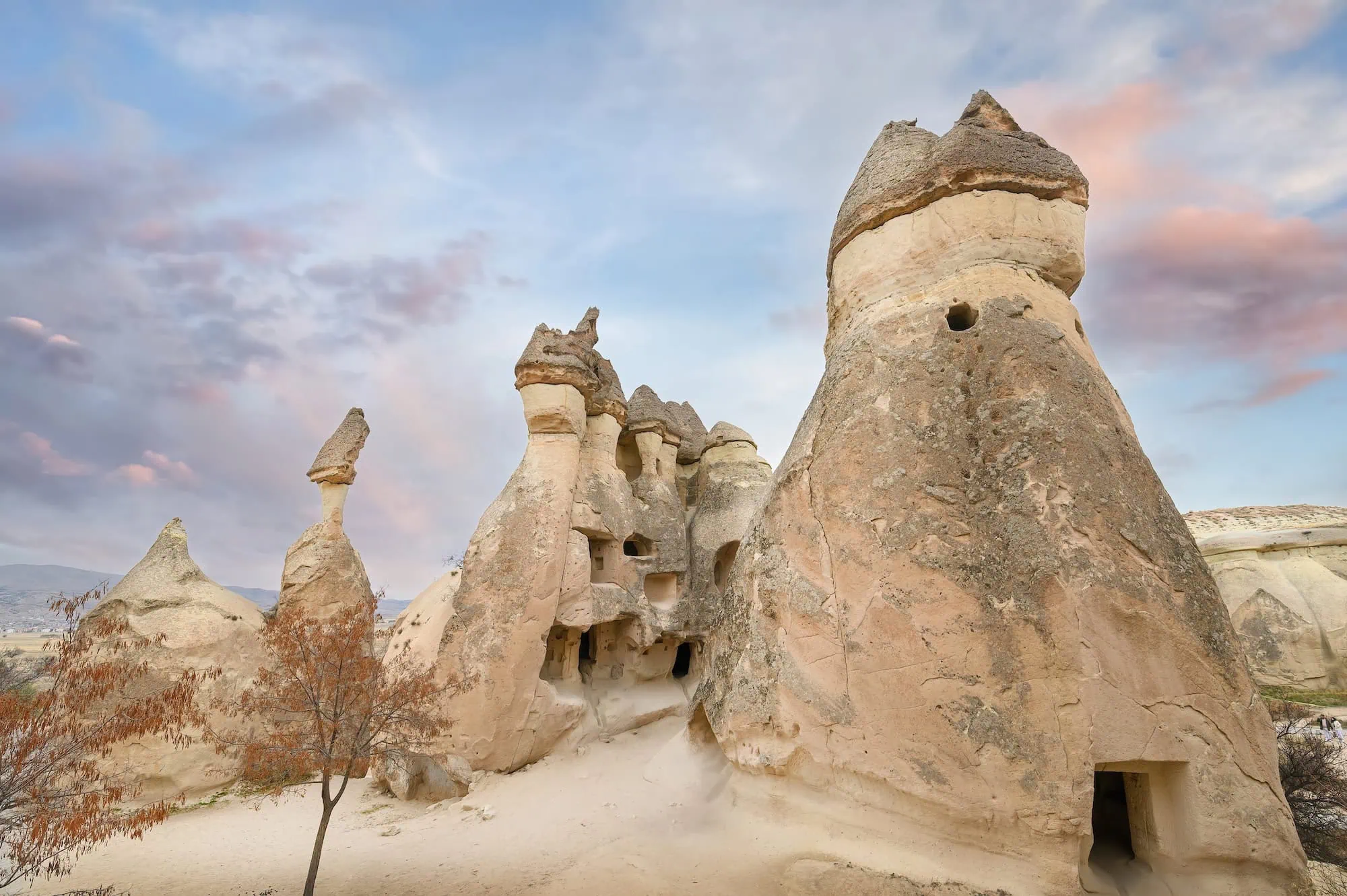 Fairy chimney rock formations in Cappadocia showing geological layers and cave dwellings carved into stone
