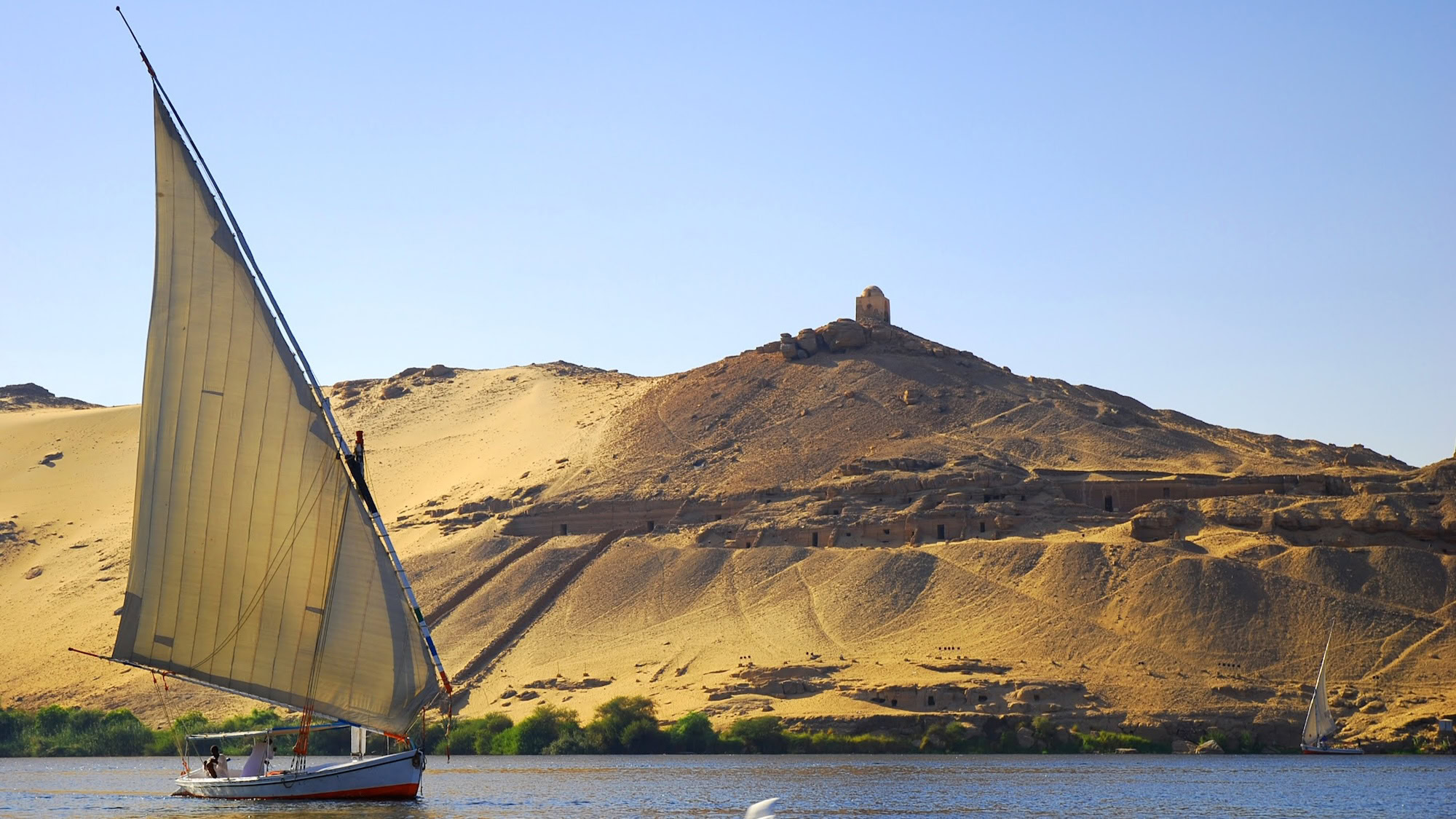 Ancient tomb structures in desert hills near the Nile River at Aswan, Egypt