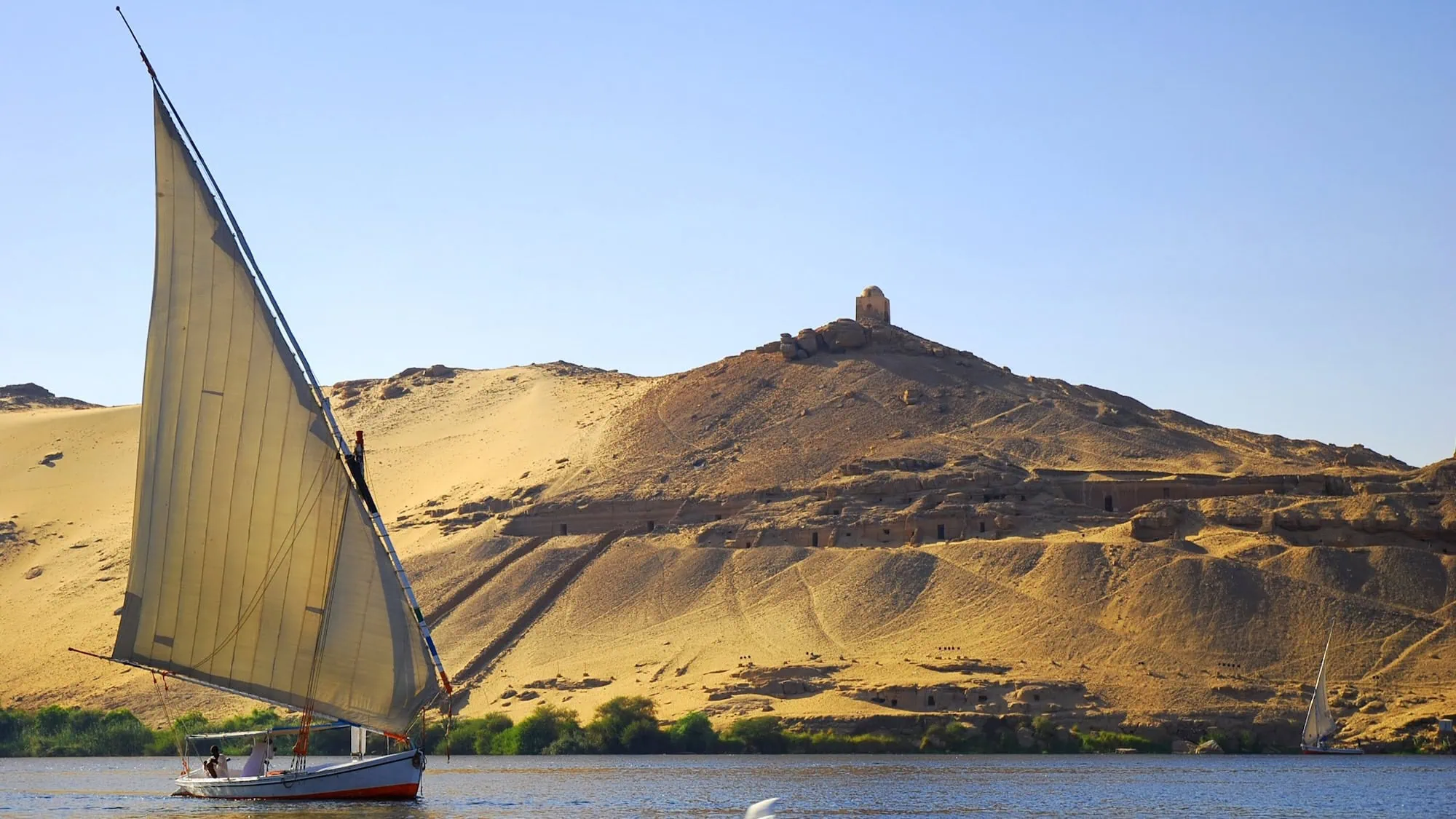 Ancient tomb structures in desert hills near the Nile River at Aswan, Egypt