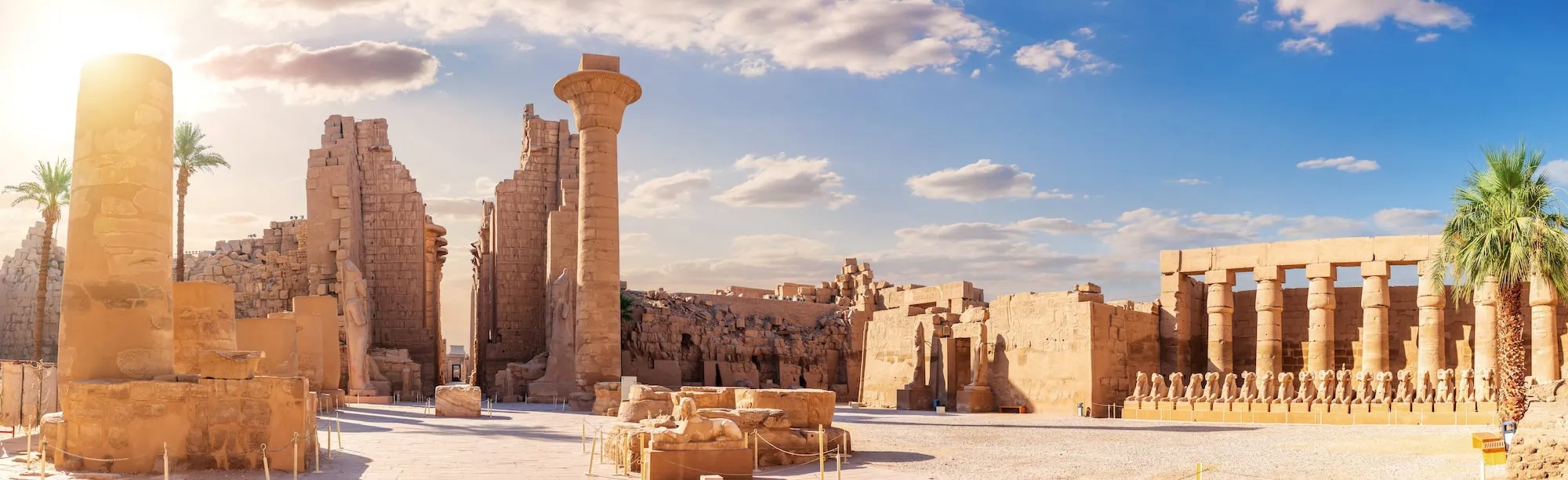 Majestic Karnak Temple complex showing ancient stone columns, sphinx statues, and hieroglyphic carvings