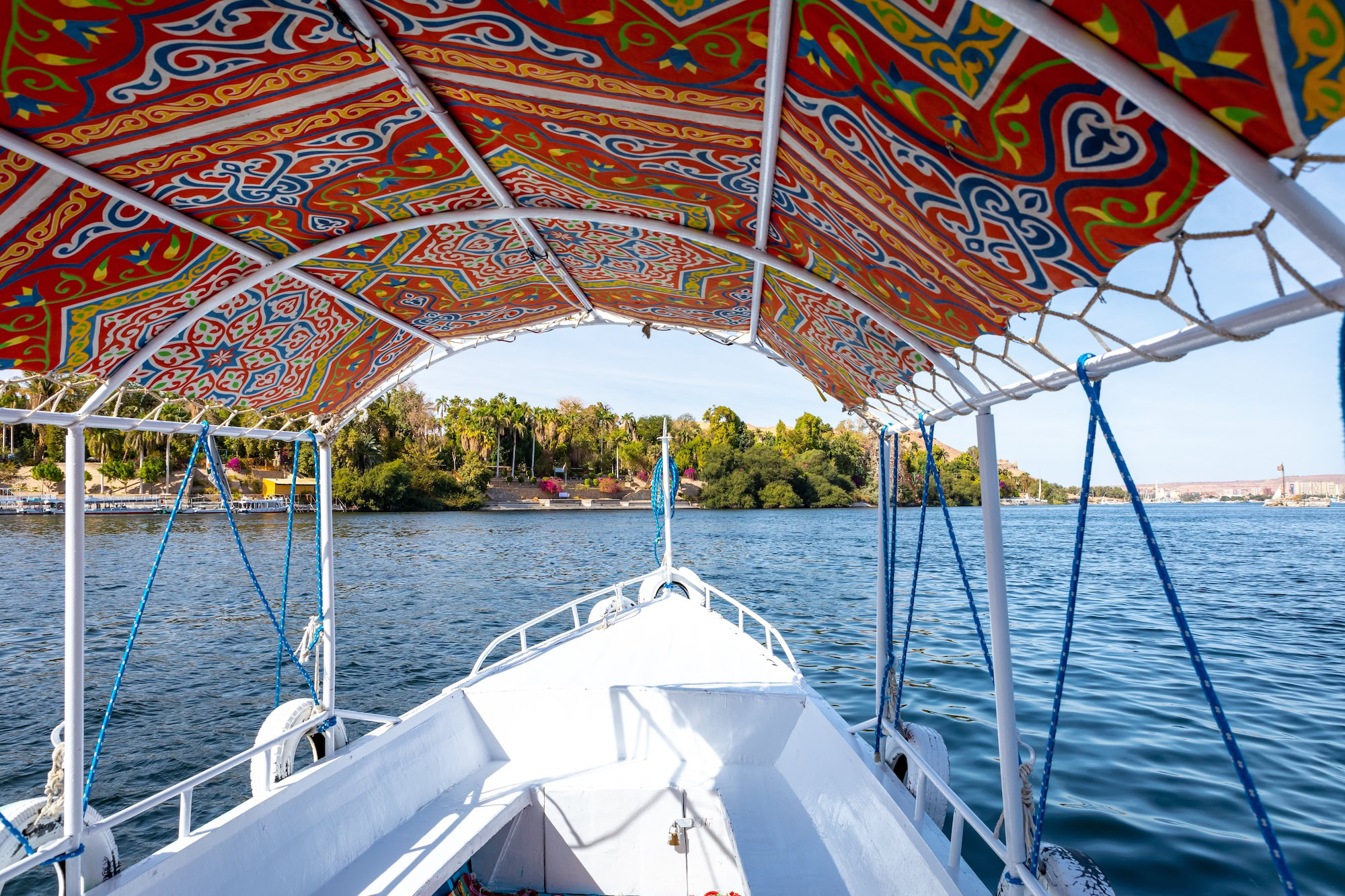 Traditional felucca boat with decorated canopy sailing on the Nile River